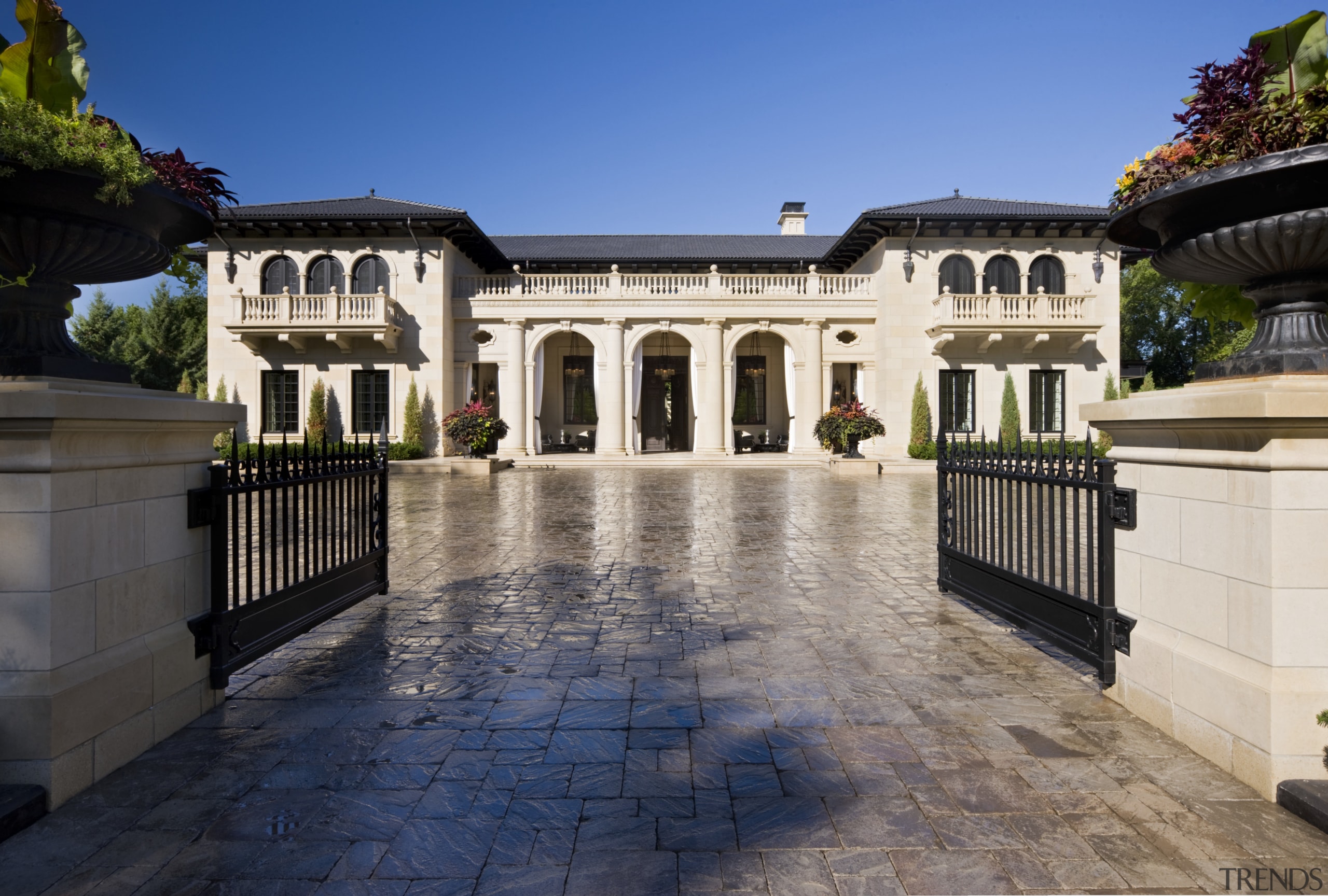 A formal symmetry reinforces the grandeur of this building, courtyard, estate, facade, hacienda, home, house, mansion, property, real estate, sky, villa