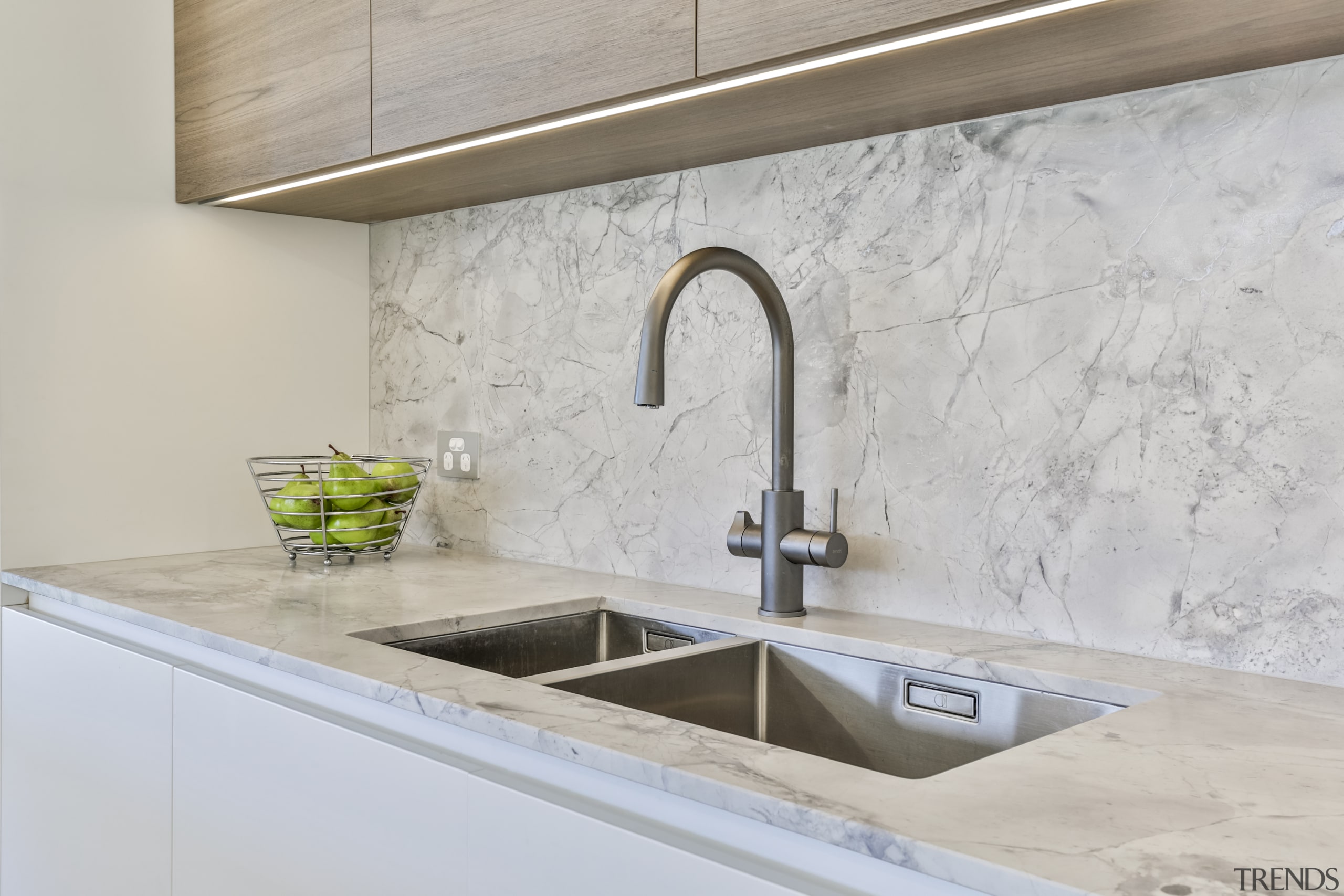 Gunmetal-toned tapware complements the white cabinetry and stone 