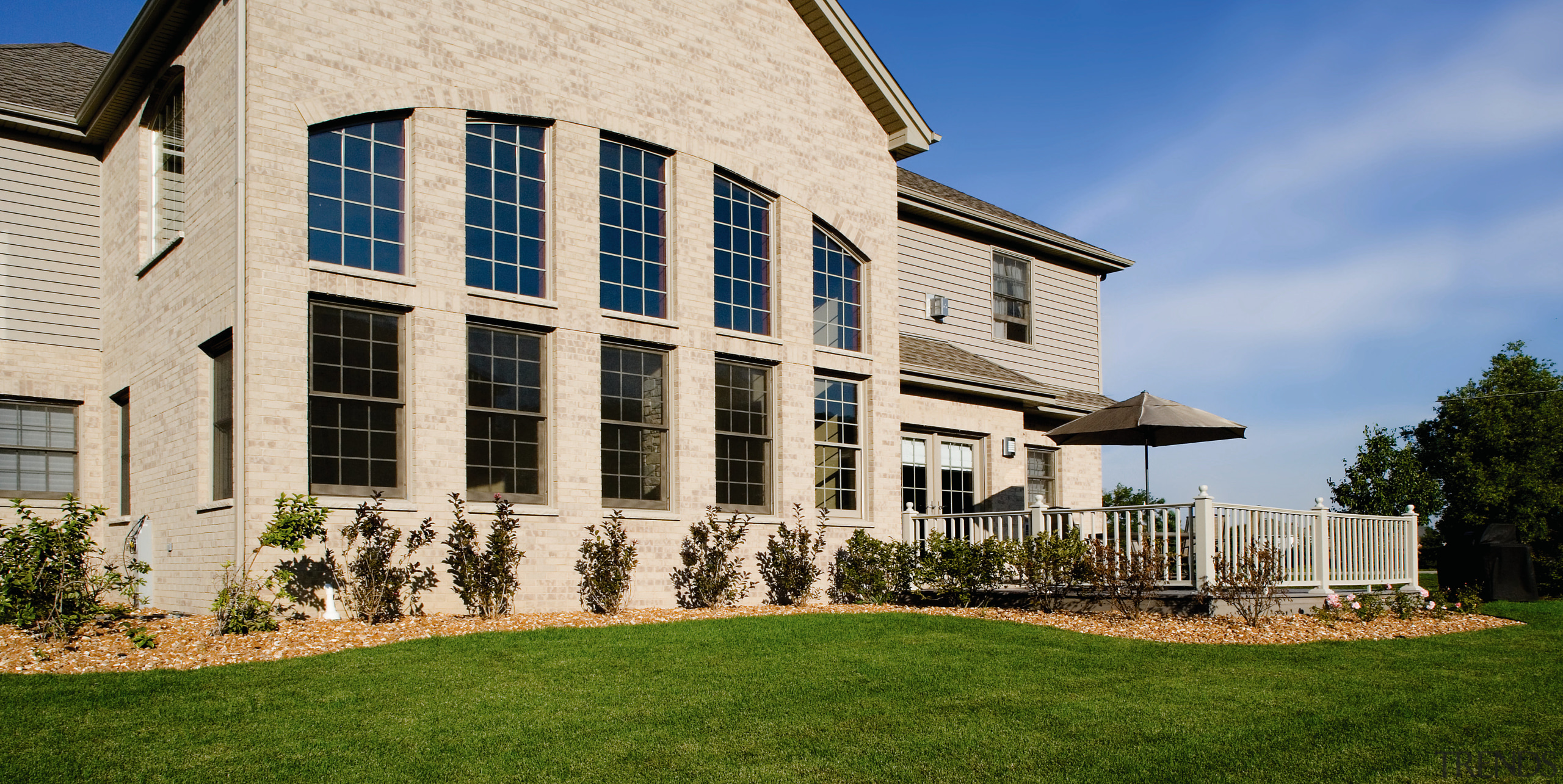 A view of some windows and doors by building, cottage, estate, facade, farmhouse, grass, home, house, lawn, mansion, property, real estate, residential area, siding, window, gray, brown