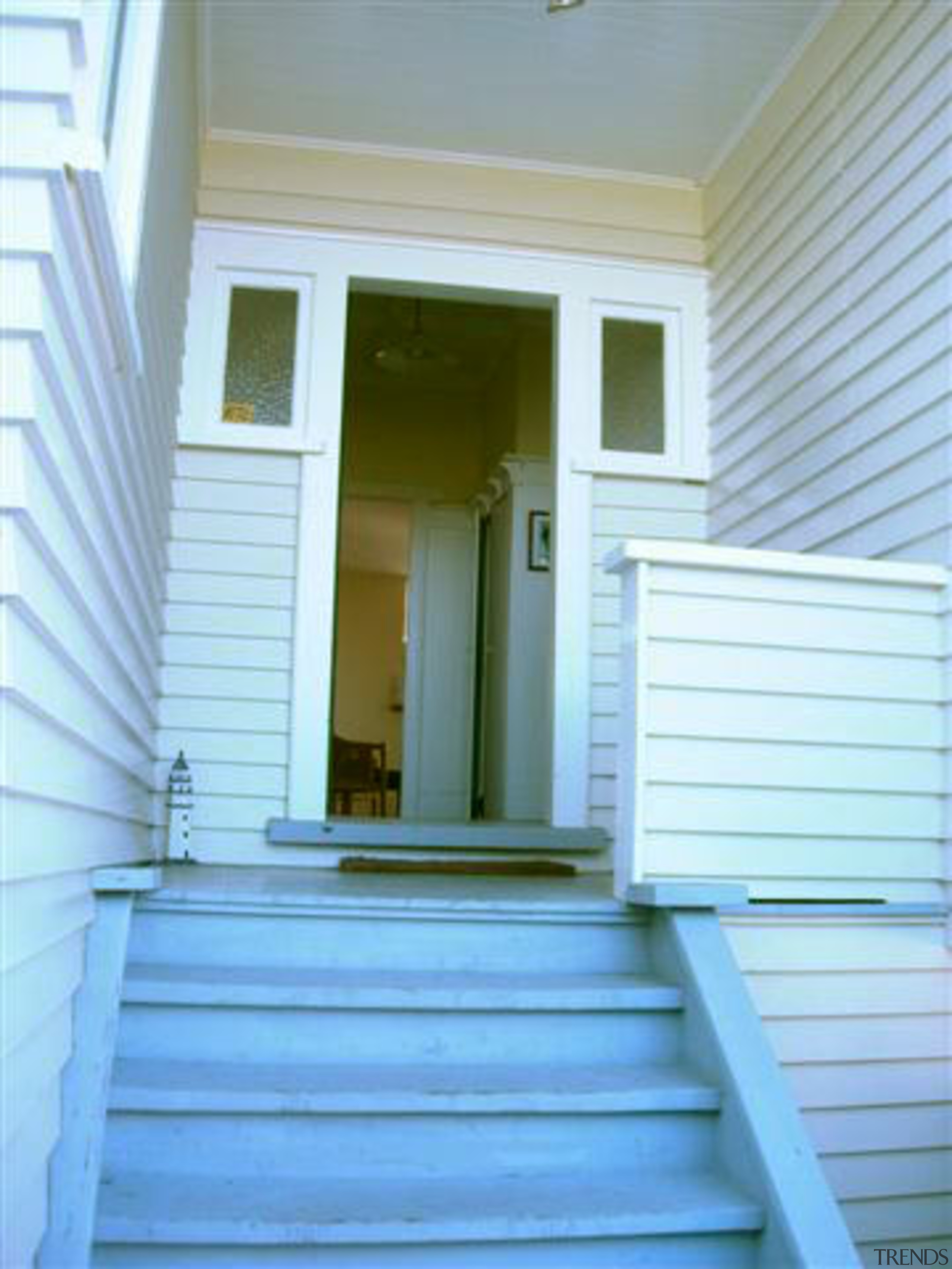 The renovated house features an elevated deck on architecture, blue, daylighting, door, facade, home, house, molding, porch, property, real estate, siding, stairs, structure, wall, window, window covering, wood, yellow, teal, white