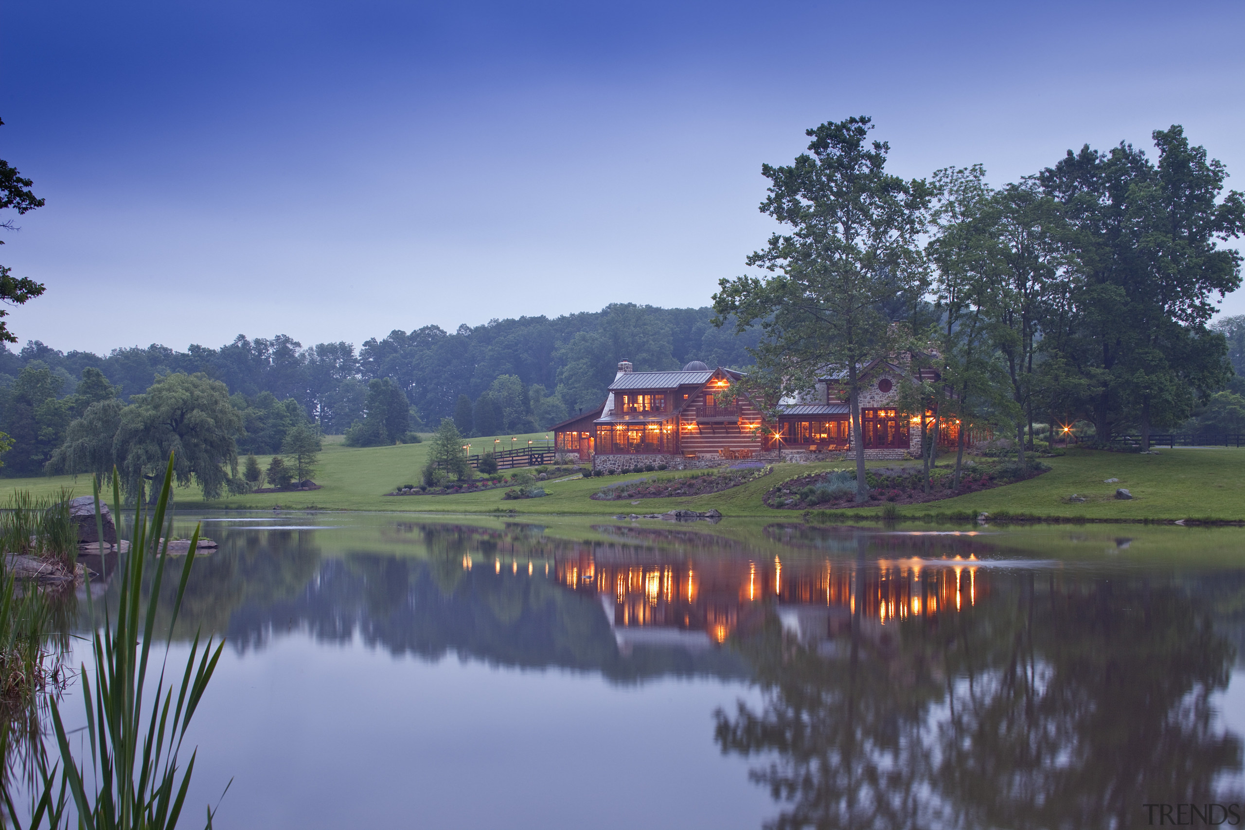 Long shot of home with lights on and bank, cloud, evening, field, grass, hill station, lake, landscape, morning, mount scenery, mountain, nature, plant, reflection, reservoir, rural area, sky, tourist attraction, tree, water, wetland, blue