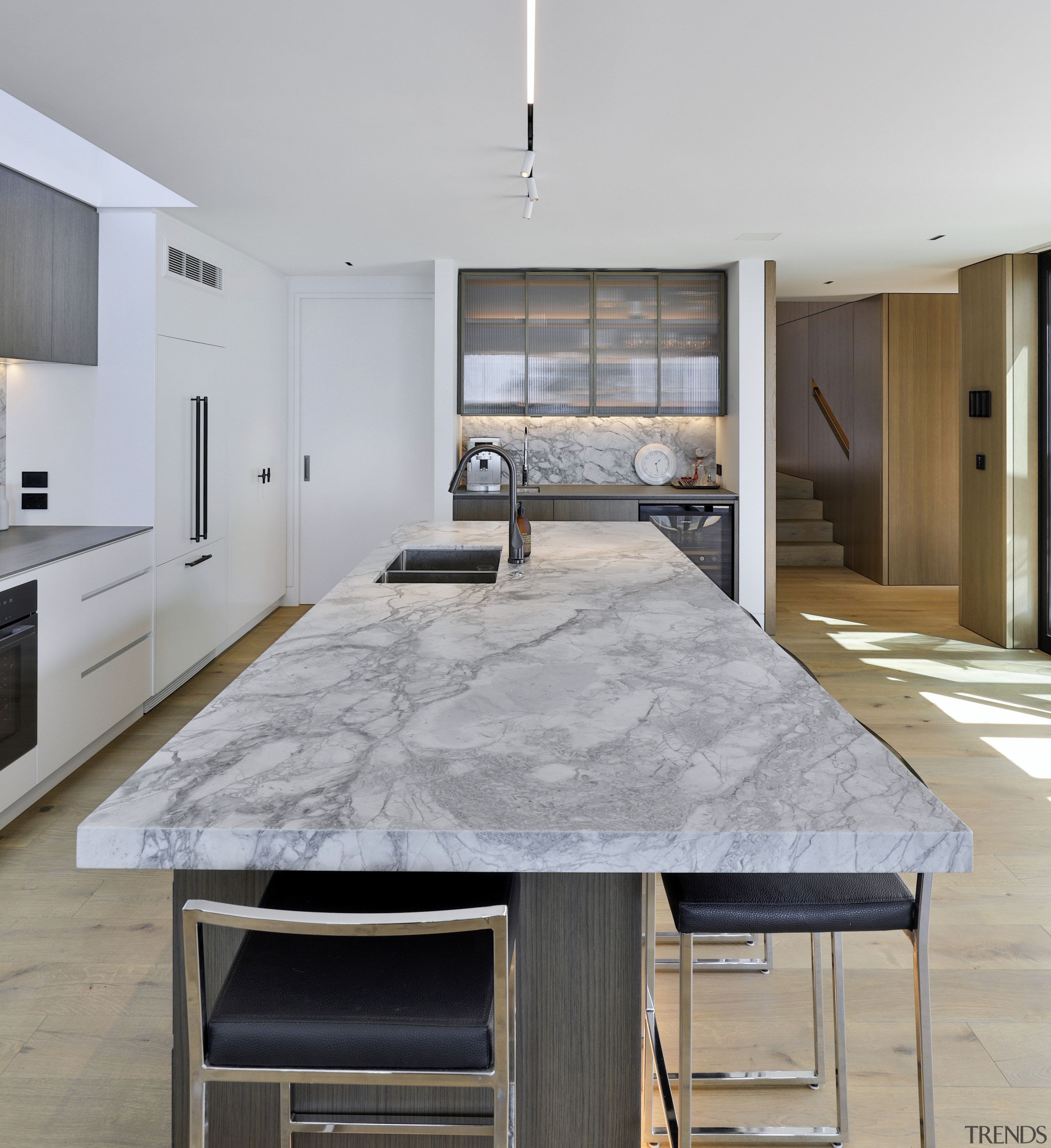 A veined white stone benchtop is the kitchen's 