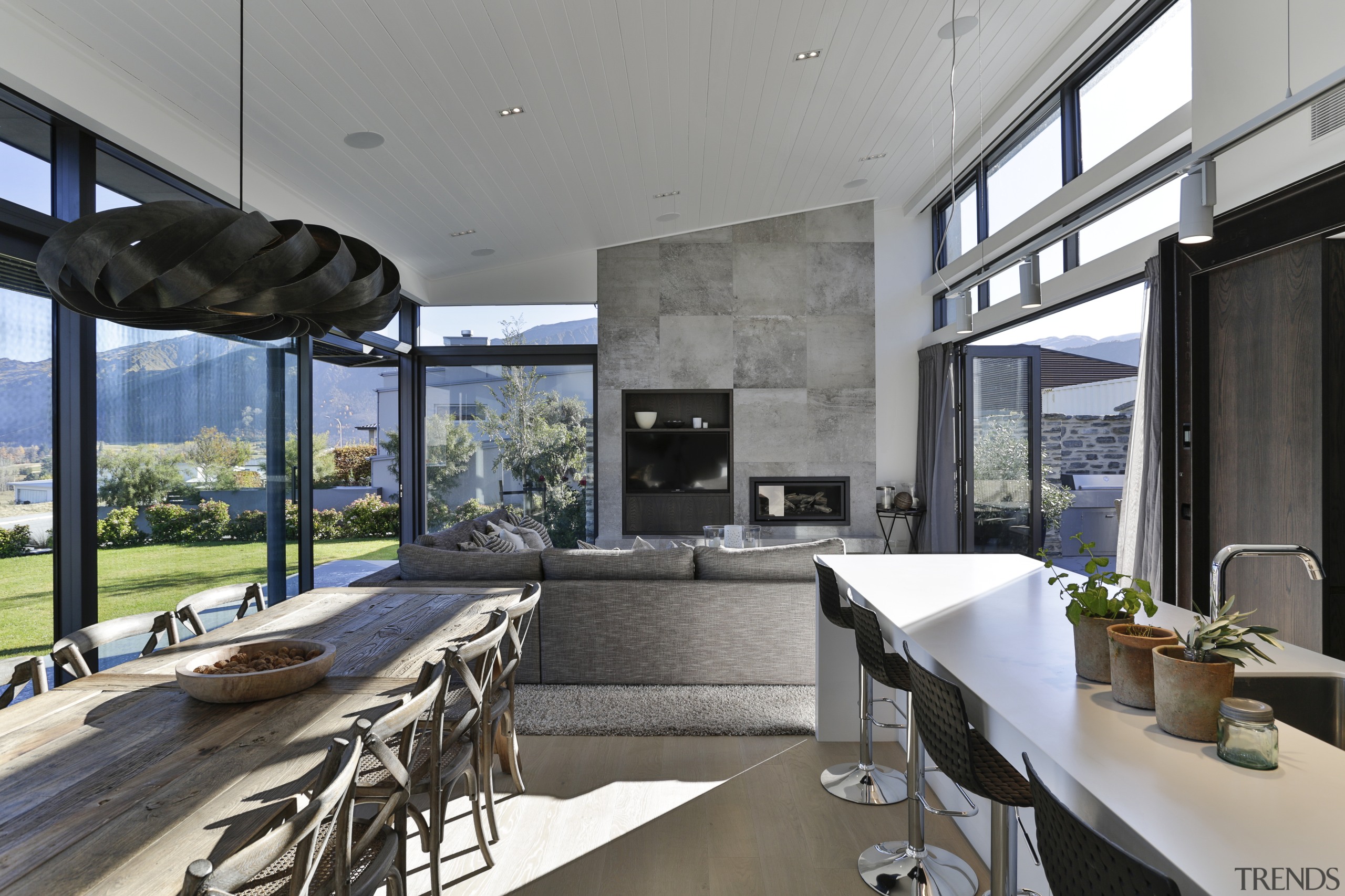 ​​​​​​​A chimney breast finished in stone-look tile anchors architecture, building, design, floor, furniture, home, house, interior design, living room, table, gray, black, kitchen,  Koia Architects