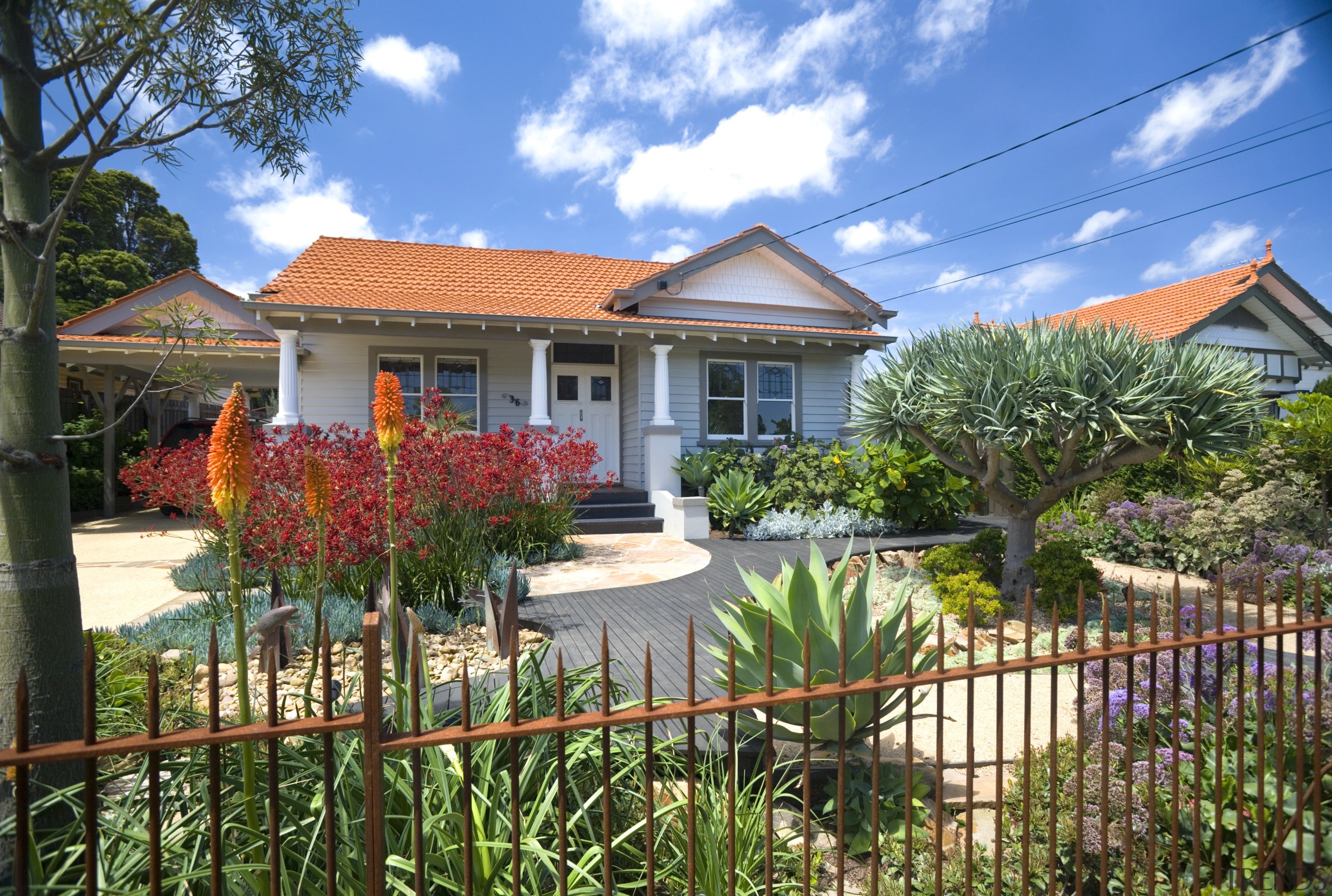 An exterior view of the entrance way to cottage, estate, facade, garden, home, house, mansion, neighbourhood, plant, property, real estate, residential area, sky, villa