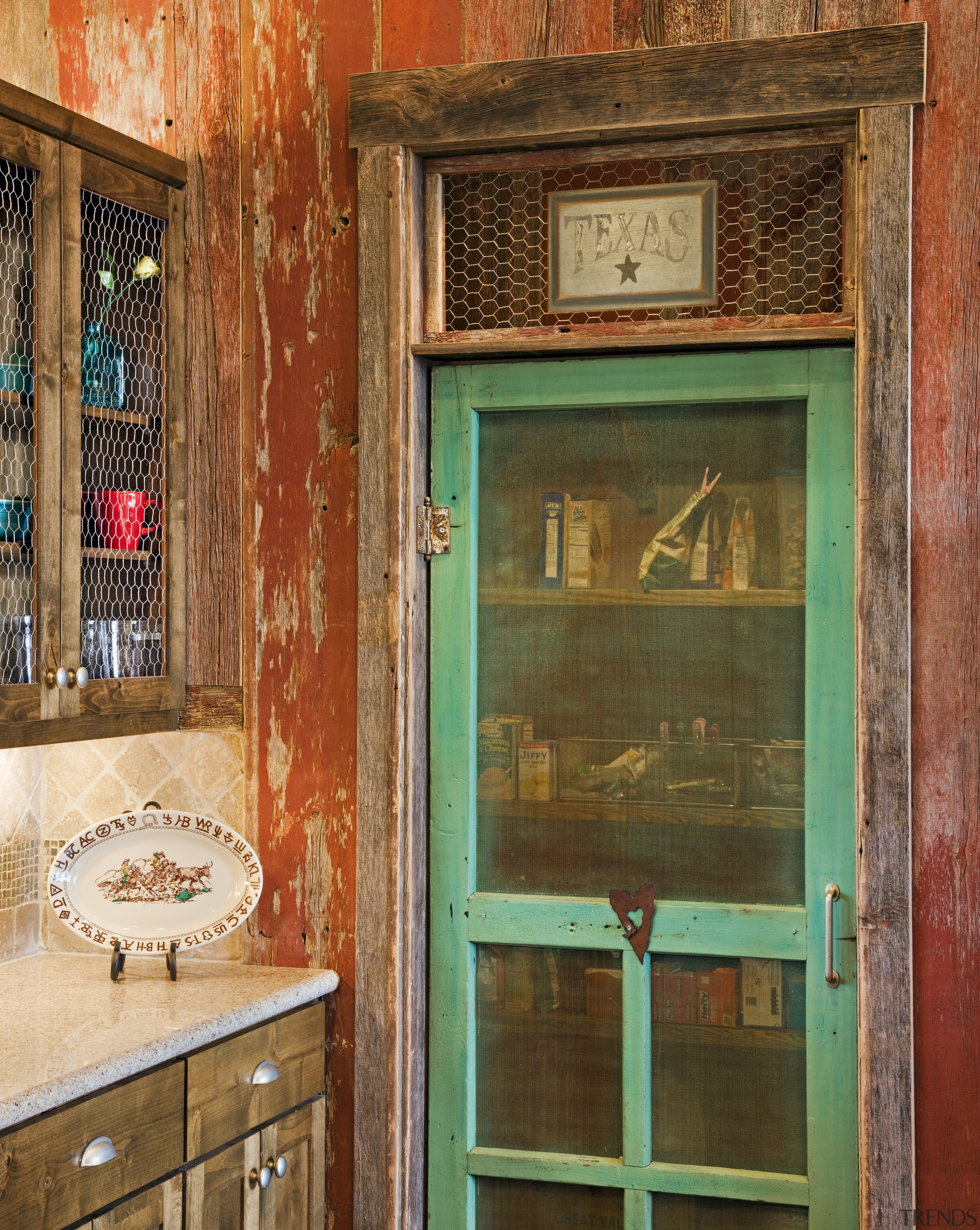 View of a farmhouse styled kitchen which features door, window, brown