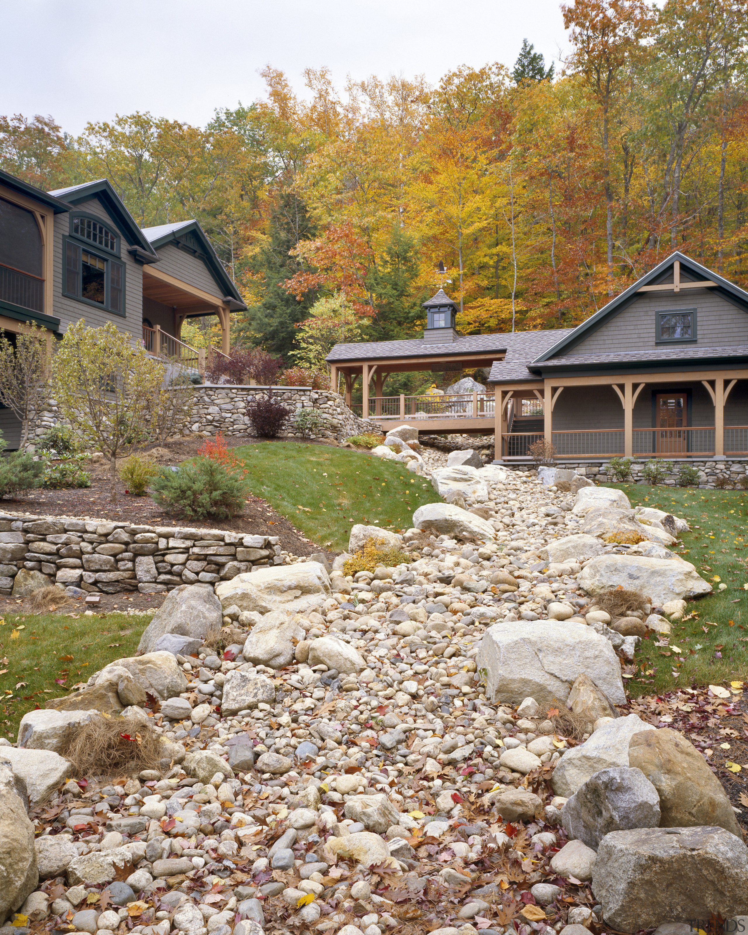 View of the holiday homes exterior featuring white autumn, cottage, home, house, landscape, landscaping, leaf, outdoor structure, plant, real estate, rock, stone wall, tree, walkway, yard, brown, white