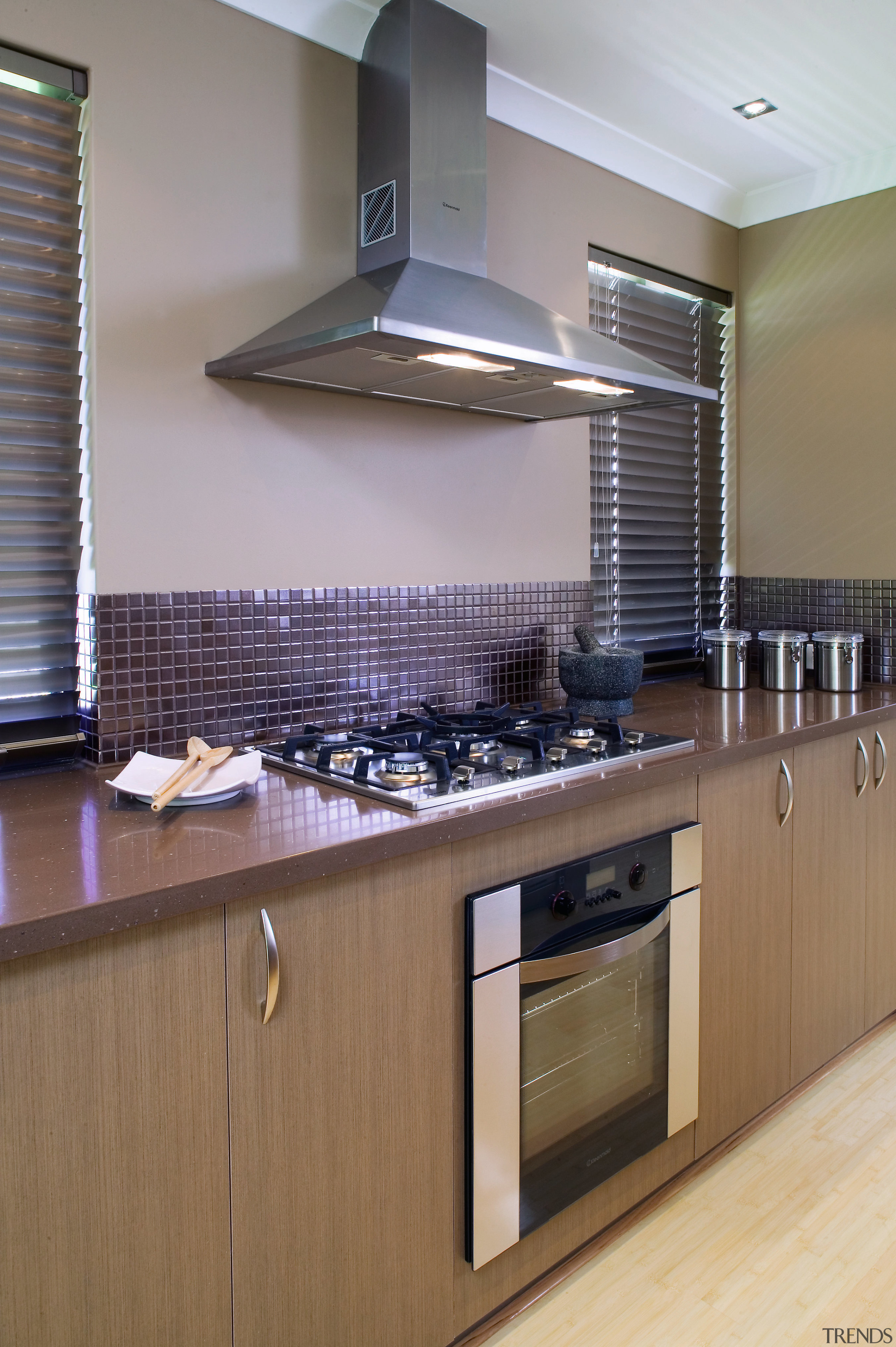 Kitchen with timber cabinetry, Coran benchtops and stainless cabinetry, countertop, flooring, interior design, kitchen, room, under cabinet lighting, gray, brown