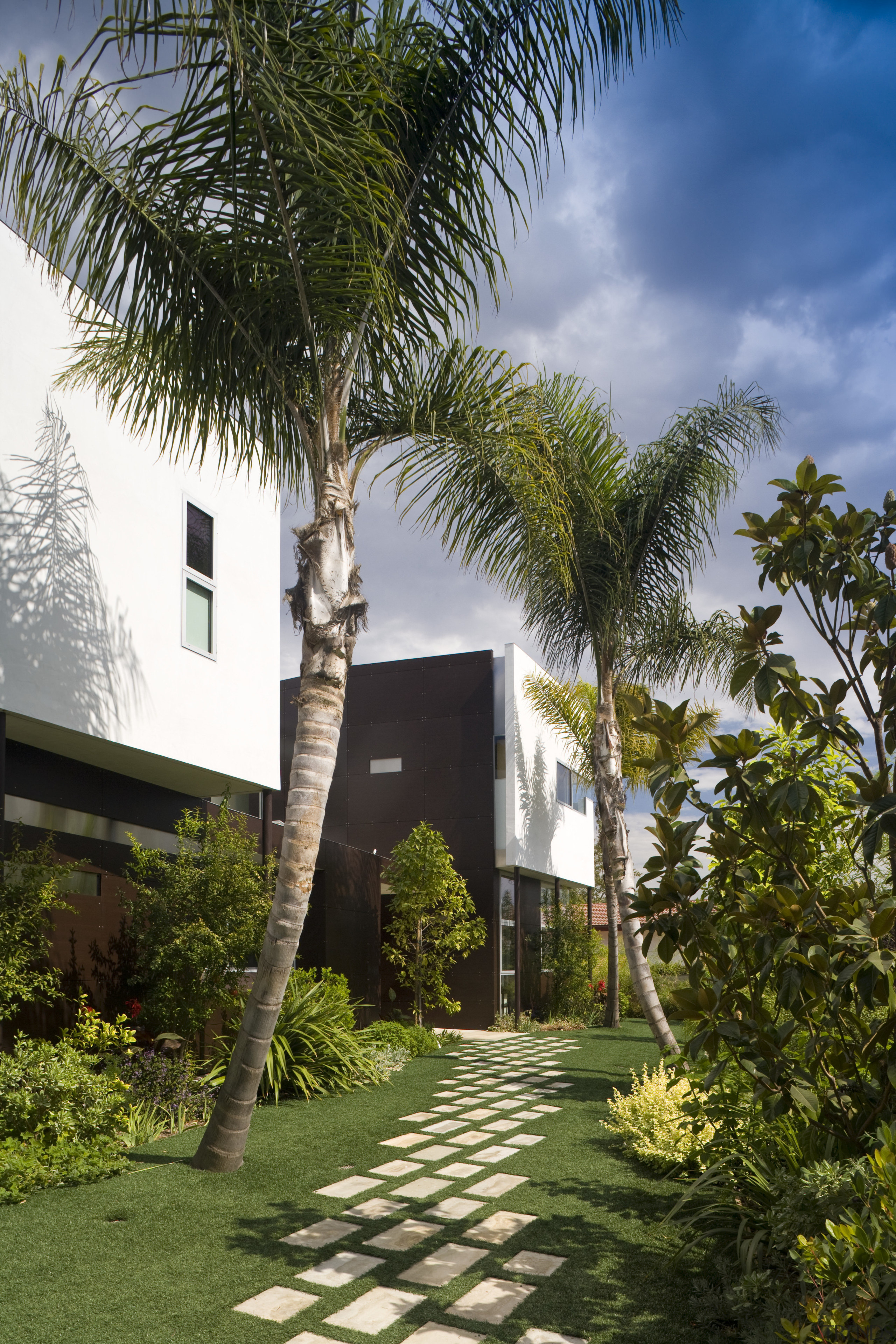 Exterior view of house and pool, featuring cladding, architecture, arecales, condominium, cottage, estate, grass, home, house, palm tree, plant, property, real estate, sky, tree, villa, brown