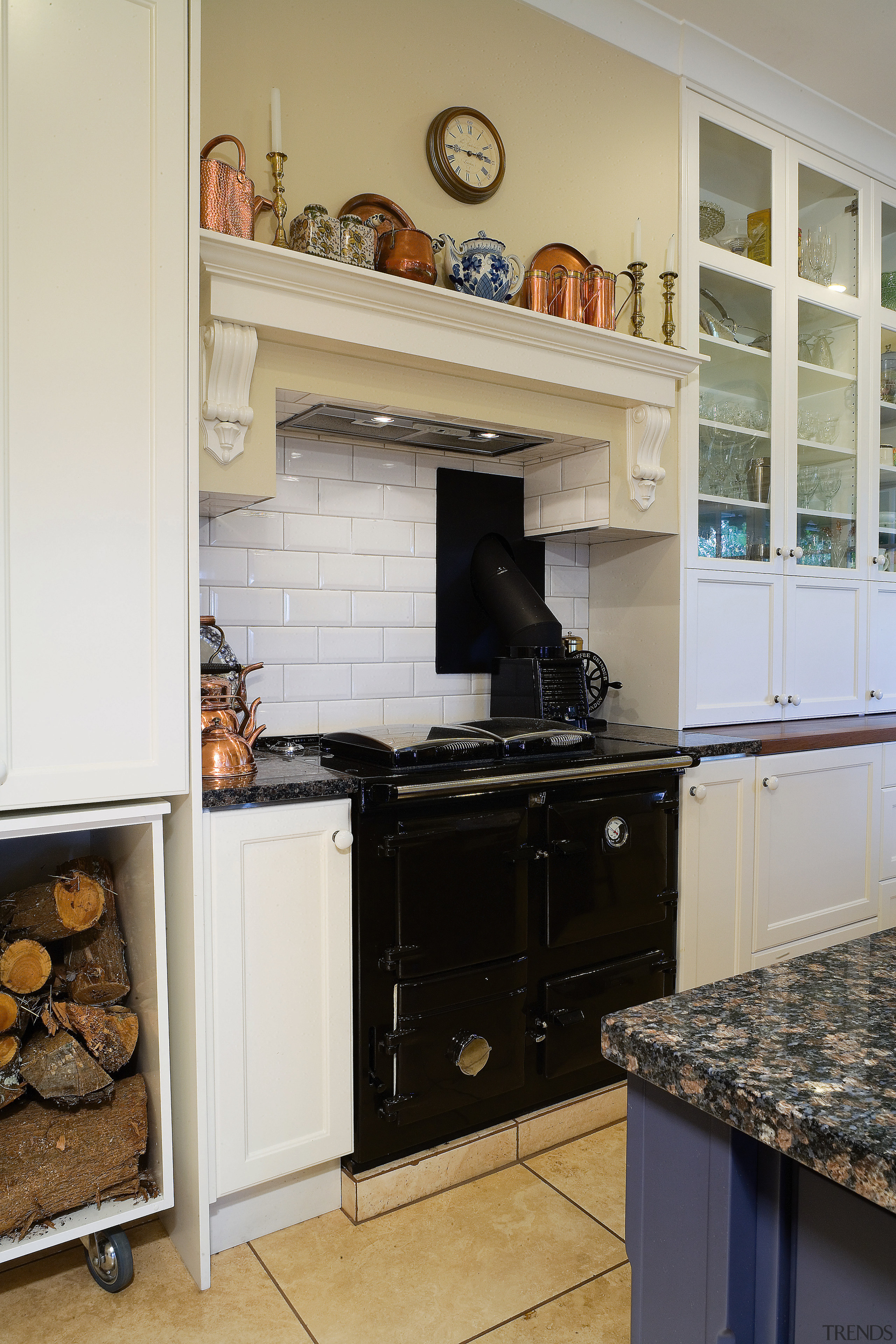 A view of this kitchen featuring tiled flooring, cabinetry, countertop, cuisine classique, floor, flooring, hearth, home, home appliance, interior design, kitchen, kitchen appliance, kitchen stove, room, tile, gray