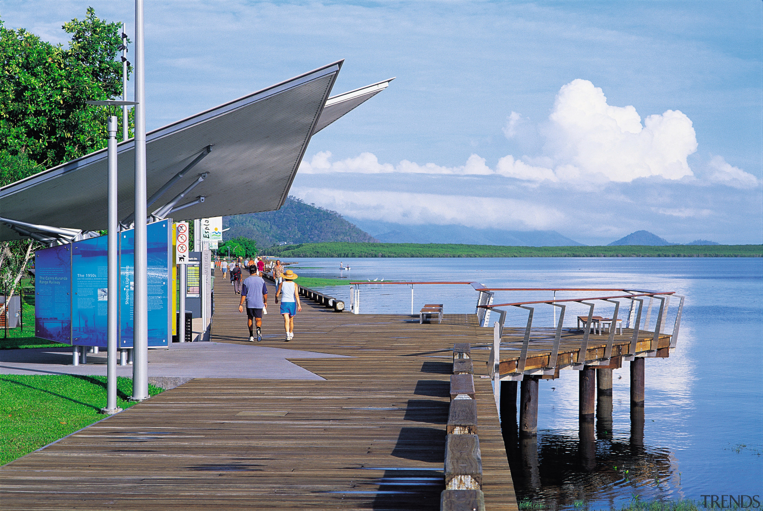 View of a wooden warf, lawn, trees, angular cloud, dock, lake, leisure, real estate, reflection, sea, shade, sky, tourism, vacation, water, teal