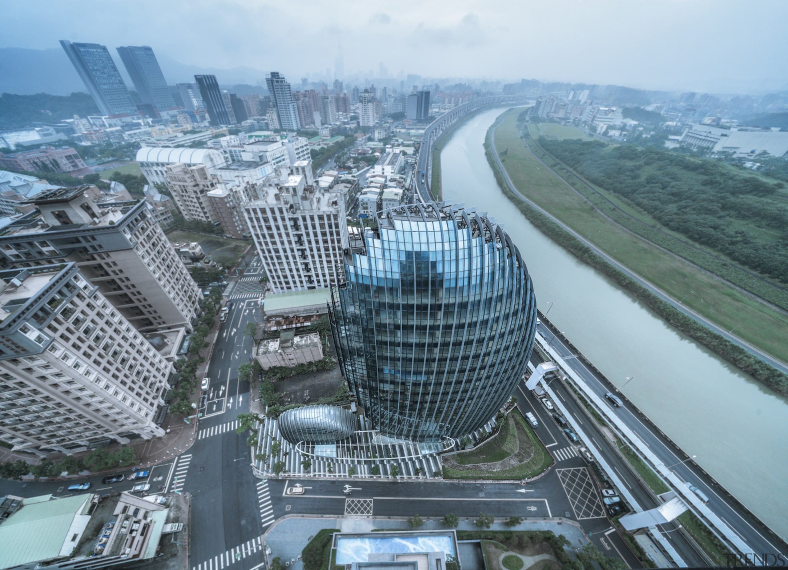 The building's egg-like shape implies it is an aerial photography, architecture, bird's-eye view, building, city, cityscape, commercial building, corporate headquarters, daytime, downtown, freeway, headquarters, human settlement, landmark, landscape, metropolis, metropolitan area, mixed-use, real estate, sky, skyline, skyscraper, tower, tower block, urban area, urban design, world, gray, teal