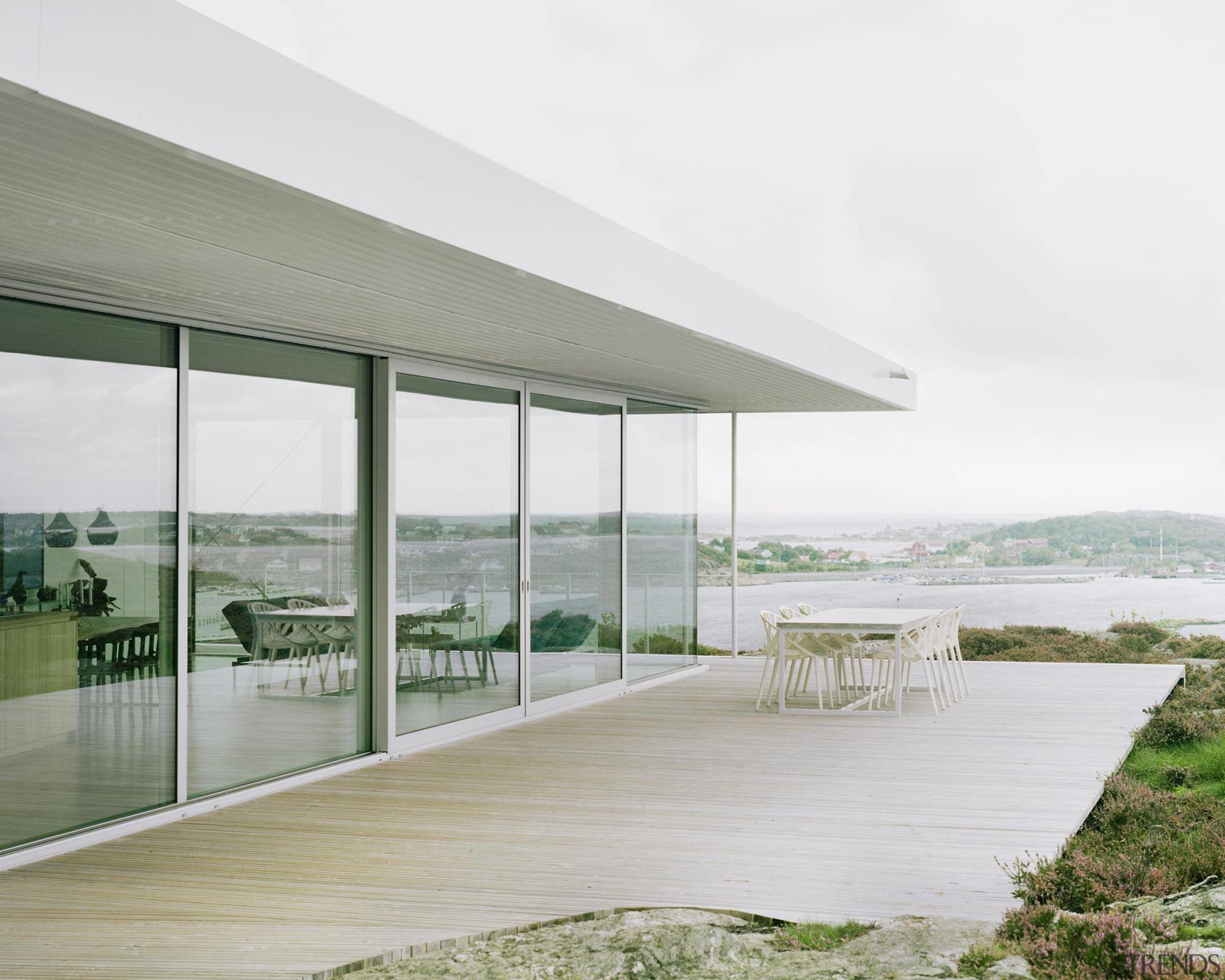 A spacious deck wraps around the sea-facing side architecture, daylighting, glass, house, interior design, shade, window, white, gray