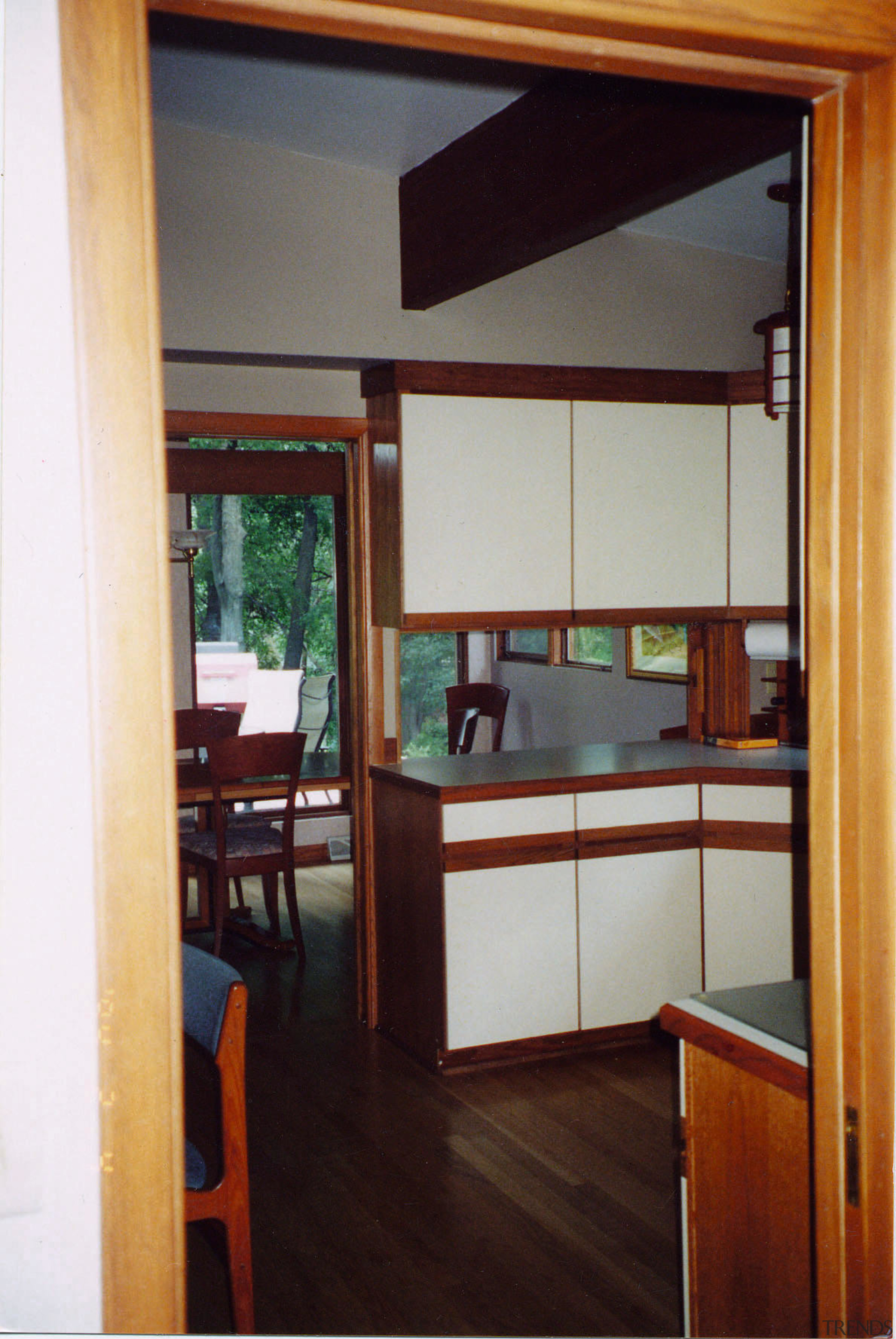 A view of the kitchen and dining areas cabinetry, door, furniture, house, interior design, room, shelving, table, window, red