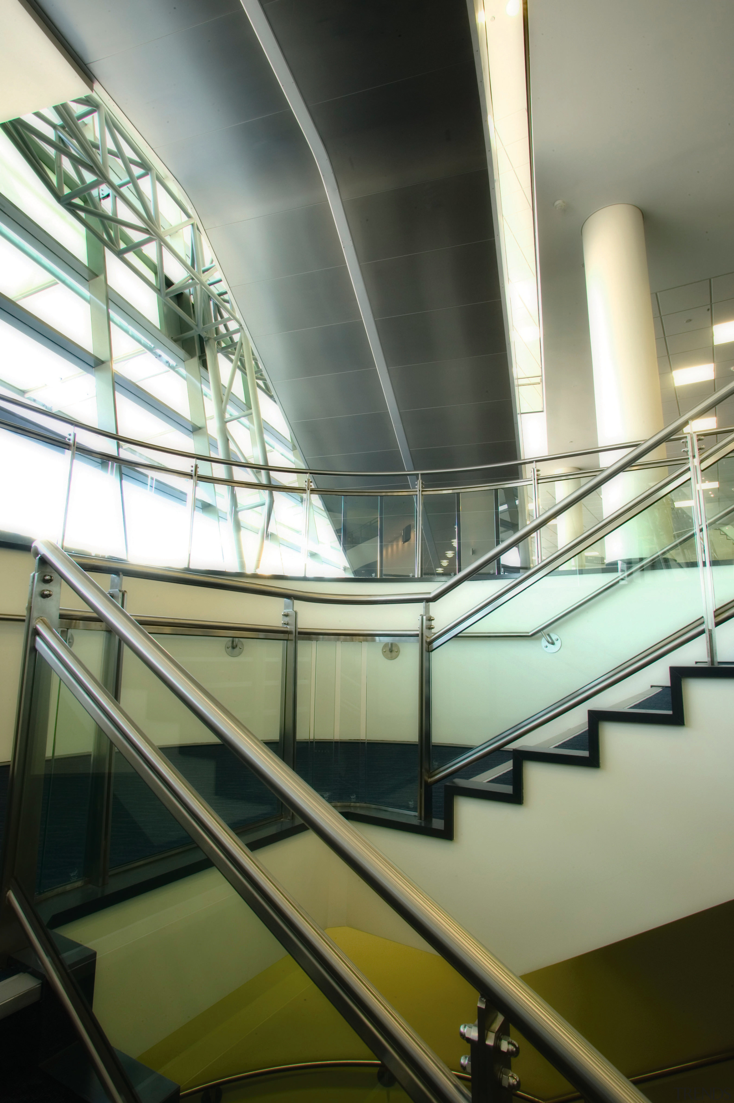 Stairway  and escalator area of building showing angle, architecture, building, condominium, daylighting, daytime, escalator, glass, handrail, line, metropolitan area, stairs, structure, brown, white