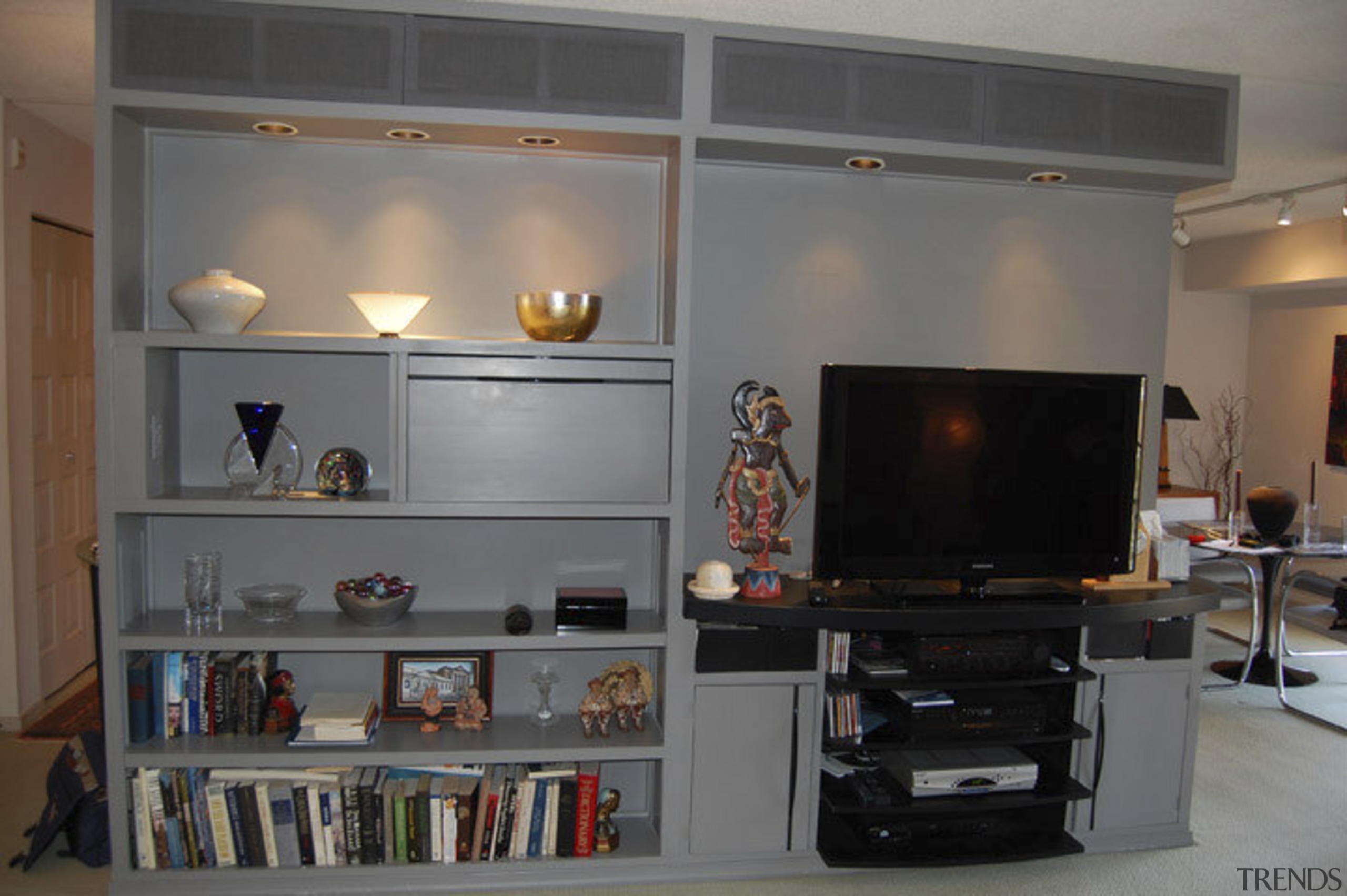 This home was remodeled by Forma Inc. A bookcase, furniture, home, interior design, living room, room, shelf, shelving, gray, black