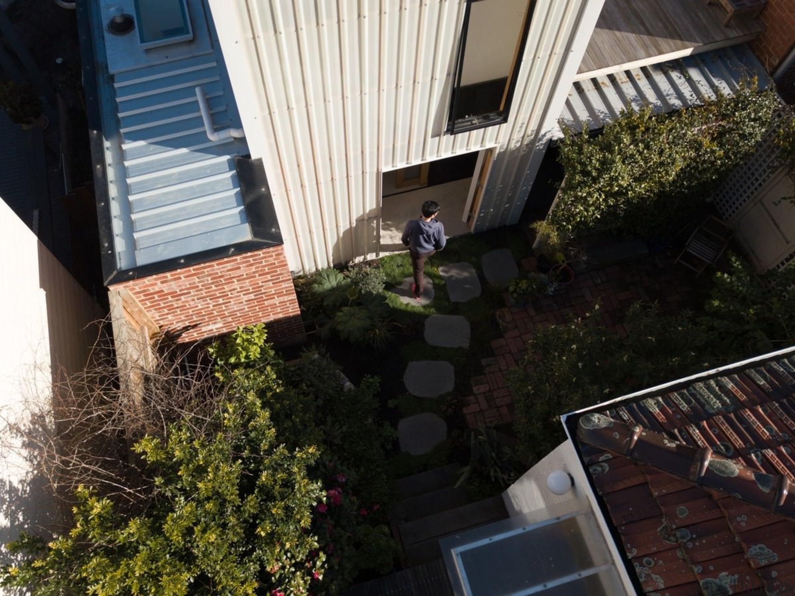 An elevated view of the courtyard - An backyard, balcony, courtyard, facade, home, house, neighbourhood, outdoor structure, plant, property, real estate, residential area, roof, tree, window, yard, black