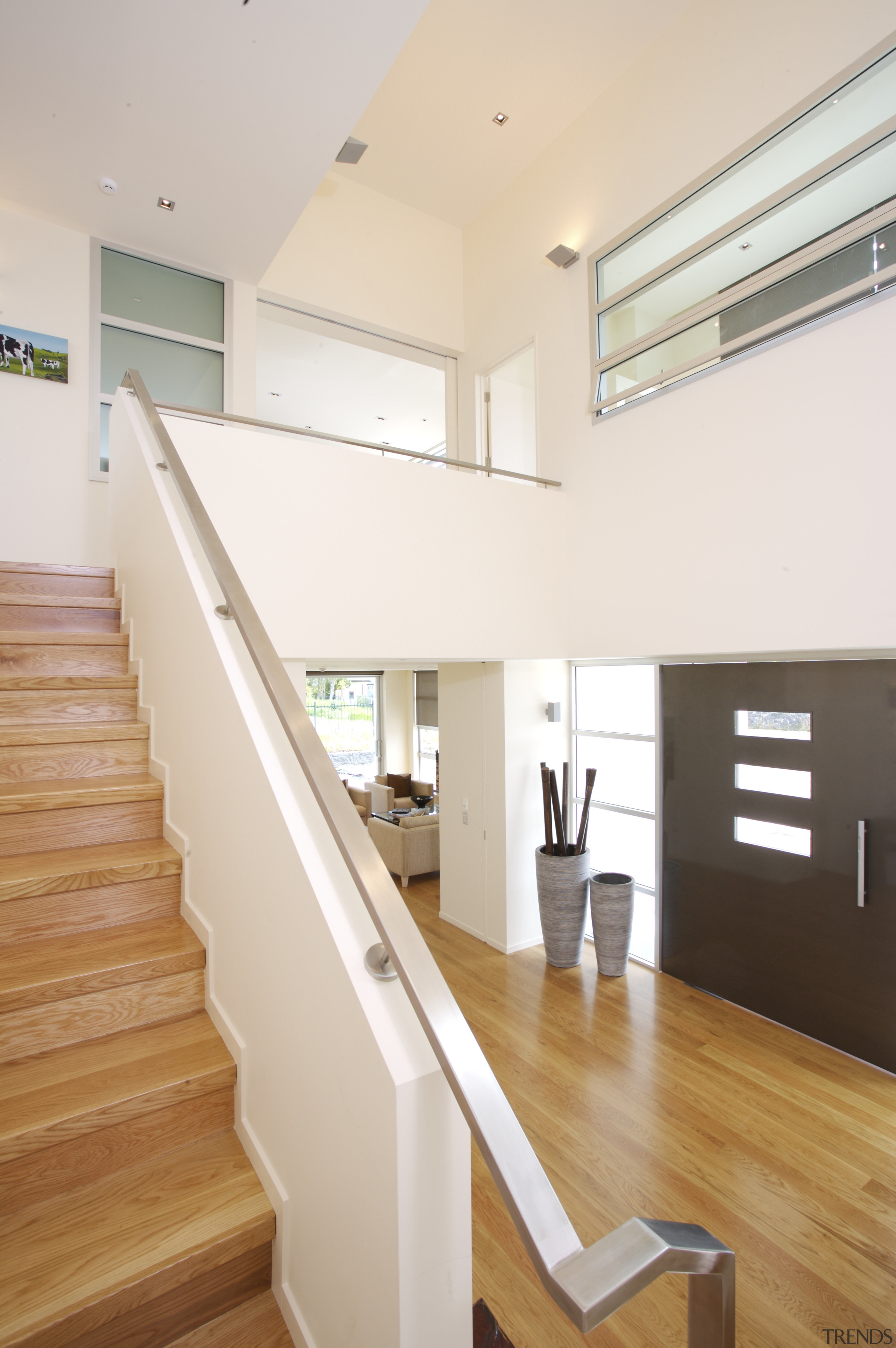 interior stairs view of a new home in architecture, ceiling, daylighting, floor, flooring, handrail, hardwood, home, house, interior design, laminate flooring, property, real estate, stairs, wall, window, wood, wood flooring, white