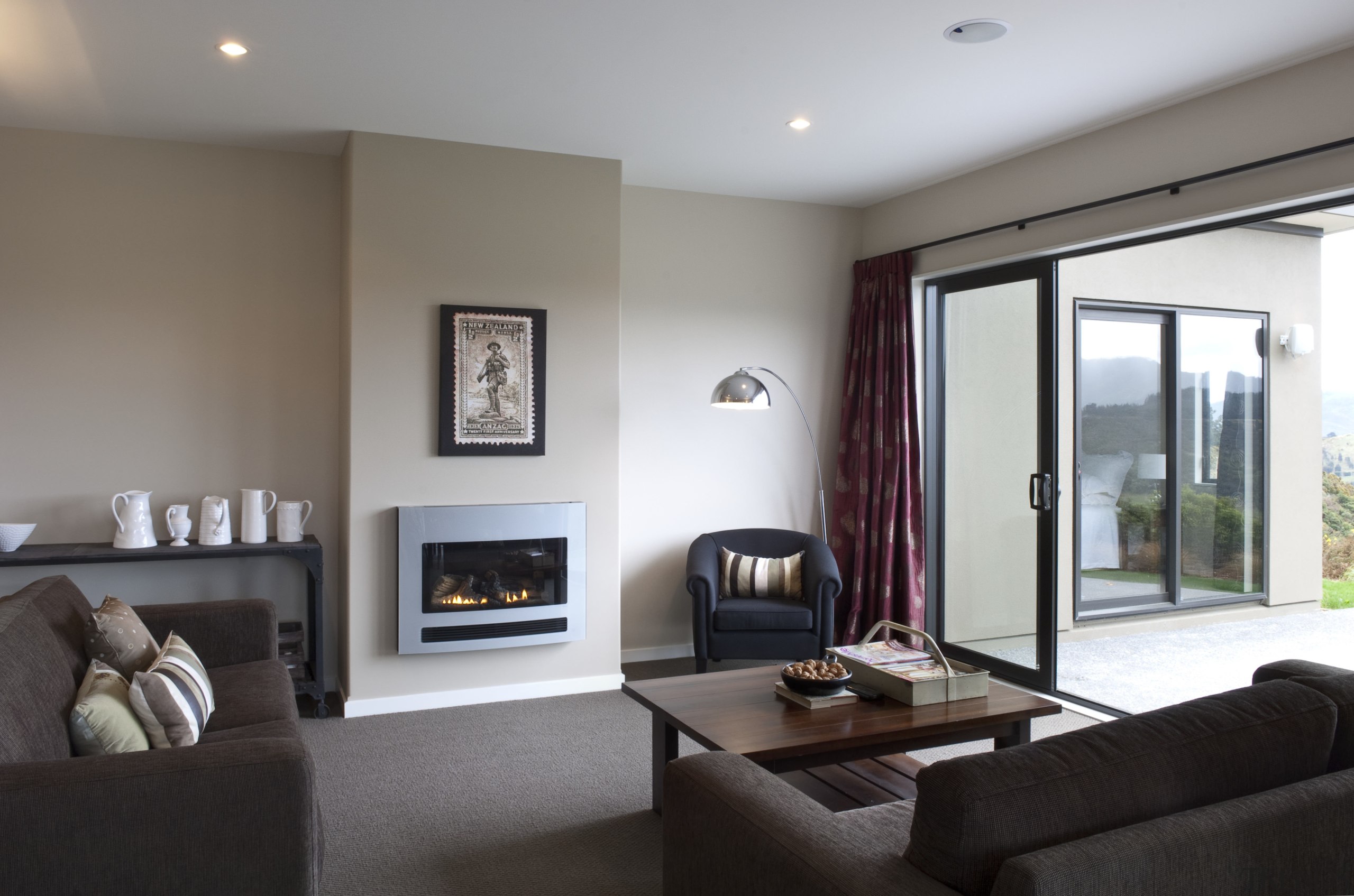 This Upper Hutt Show home was designed and ceiling, floor, flooring, hearth, home, interior design, living room, property, real estate, room, suite, window, gray, white, black