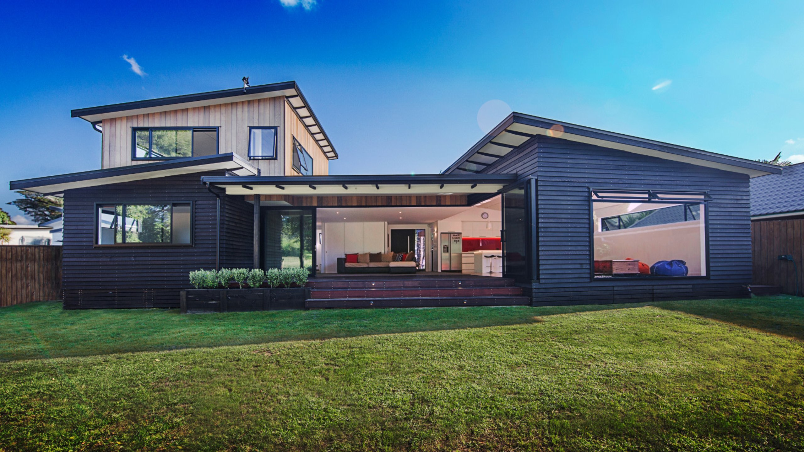 A wide shot of the entire Waitoki home cottage, elevation, estate, facade, home, house, property, real estate, residential area, siding, blue