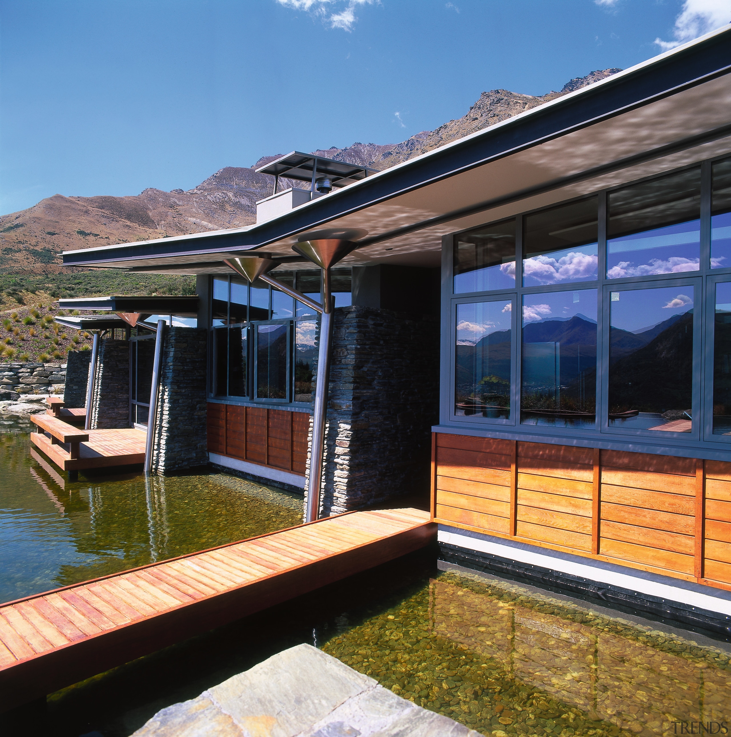 view of theis new house tucked beneath the cottage, facade, home, house, real estate, reflection, sky, water, window, wood, black