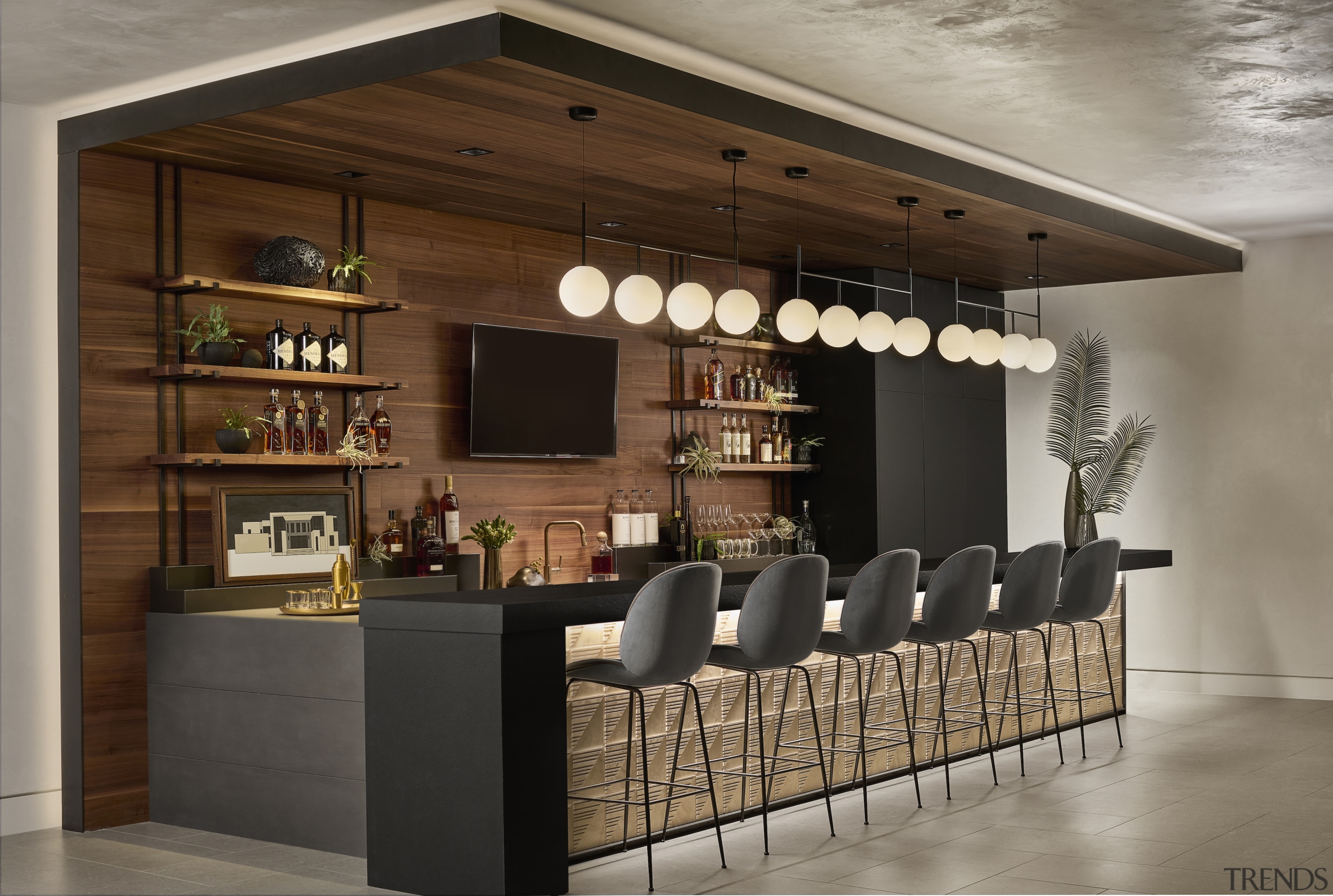 The custom bar is clad in walnut, and 