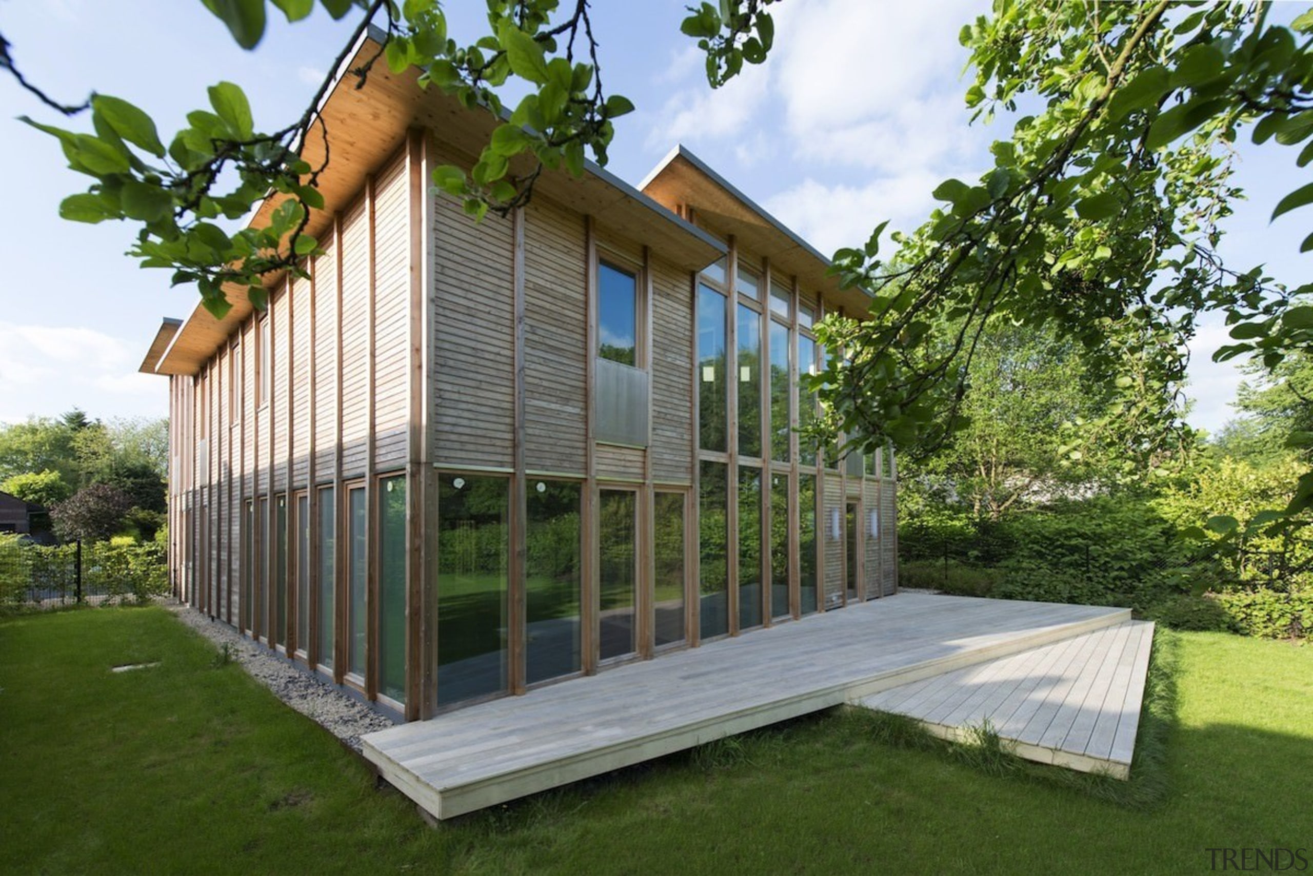 Outside, the deck flows down onto the lawn cottage, farmhouse, home, house, property, real estate, brown