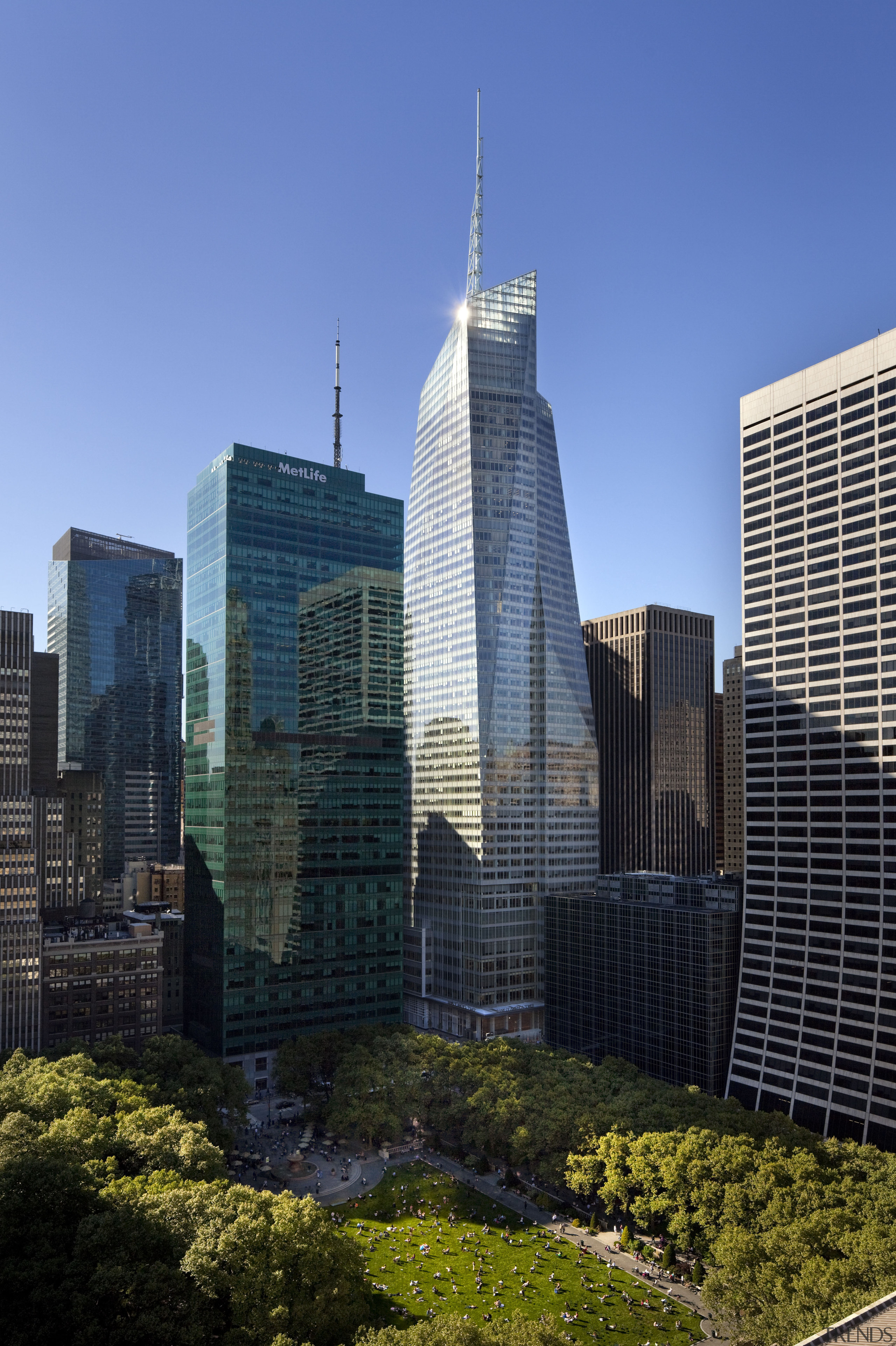 View of the Bank of America Tower in architecture, building, city, cityscape, condominium, corporate headquarters, daytime, downtown, headquarters, landmark, metropolis, metropolitan area, reflection, sky, skyline, skyscraper, tower, tower block, tree, urban area, blue, black