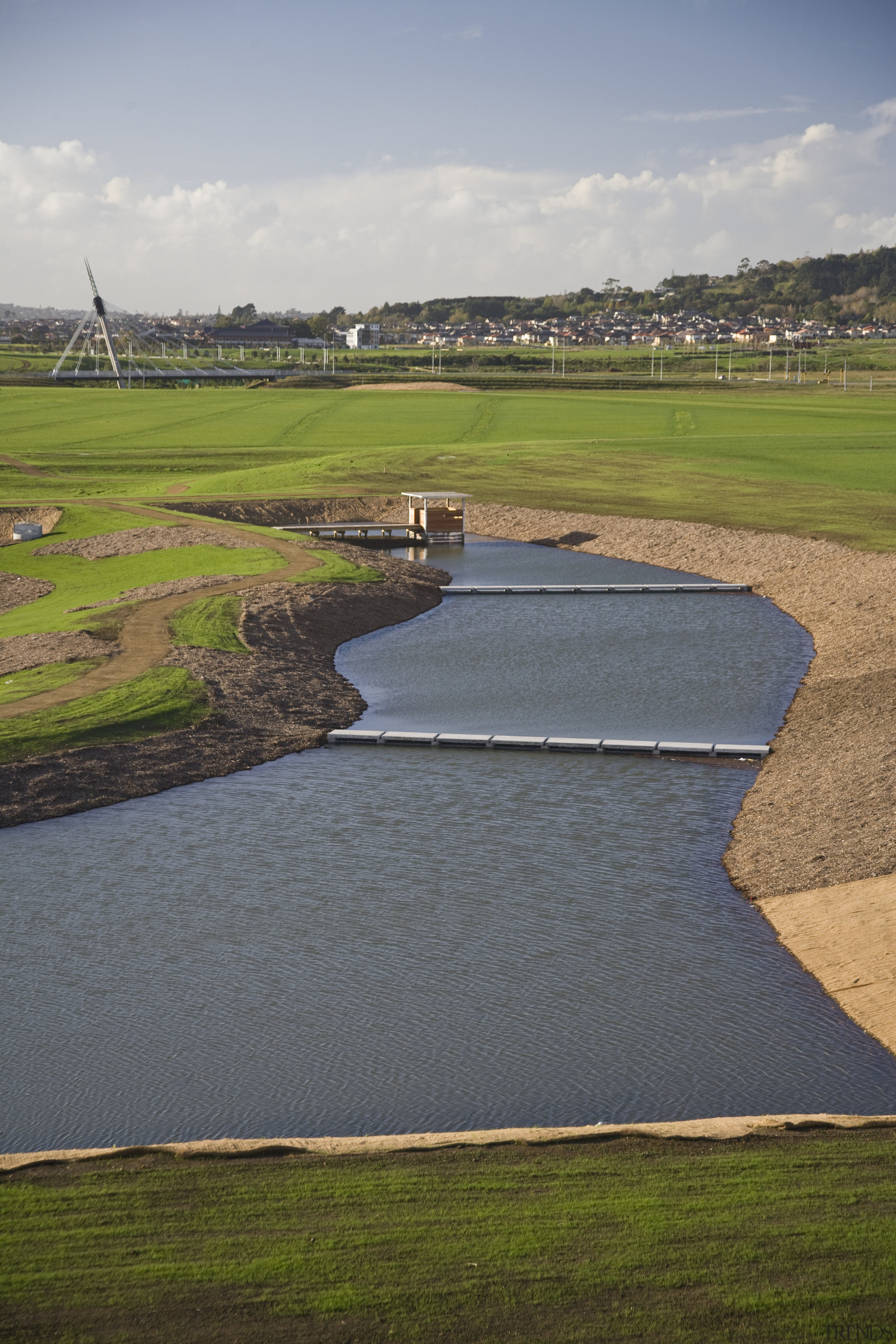 View of the Sir Barry Curtis Park which atmosphere of earth, field, golf course, grass, grassland, landscape, marsh, plain, polder, reservoir, rural area, sky, water, water resources, wetland, gray, brown