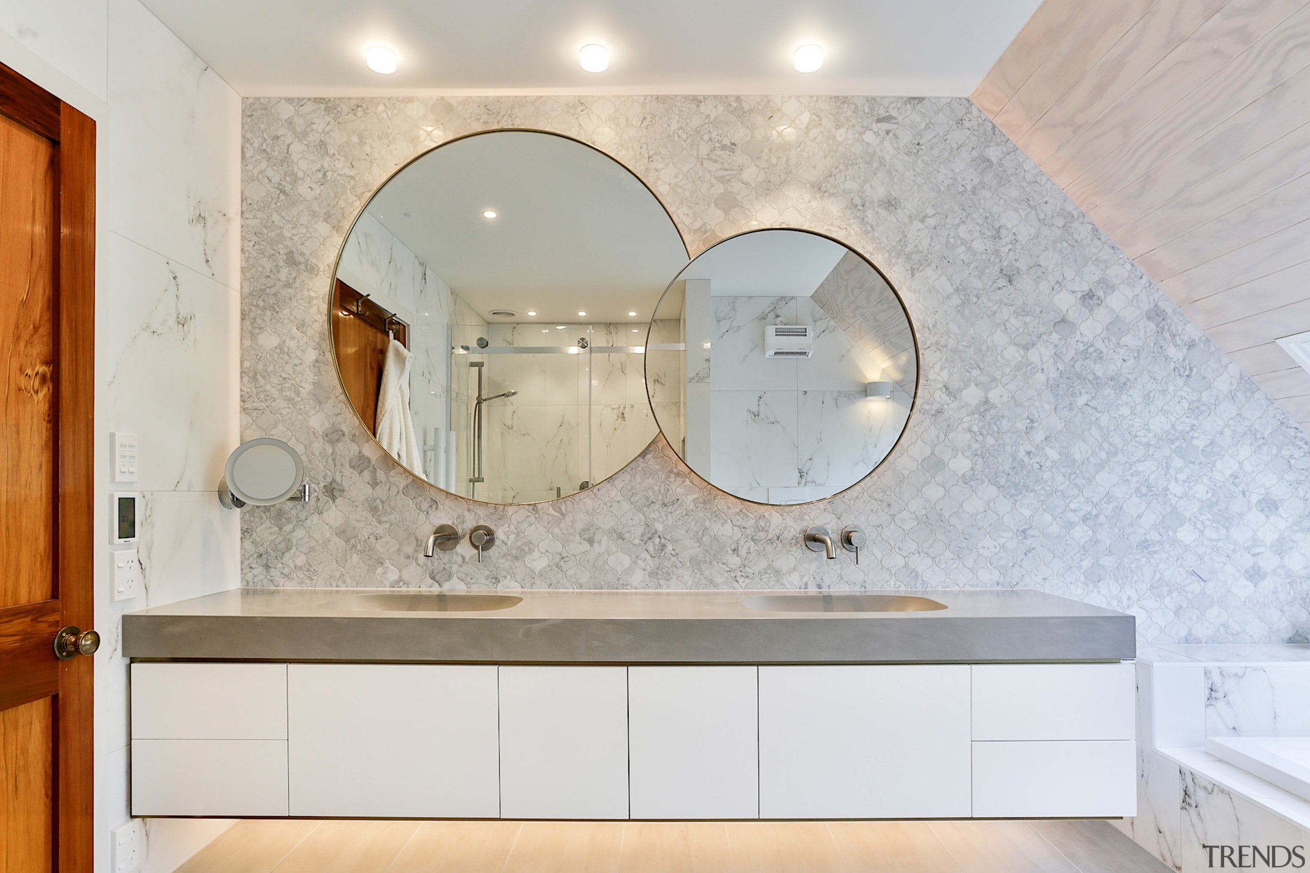 Two round mirrors are brought together in one architecture, bathroom, building, cabinetry, ceiling, countertop, floor, flooring, furniture, home, house, interior design, lighting, marble, property, real estate, room, sink, tap, tile, wall, gray