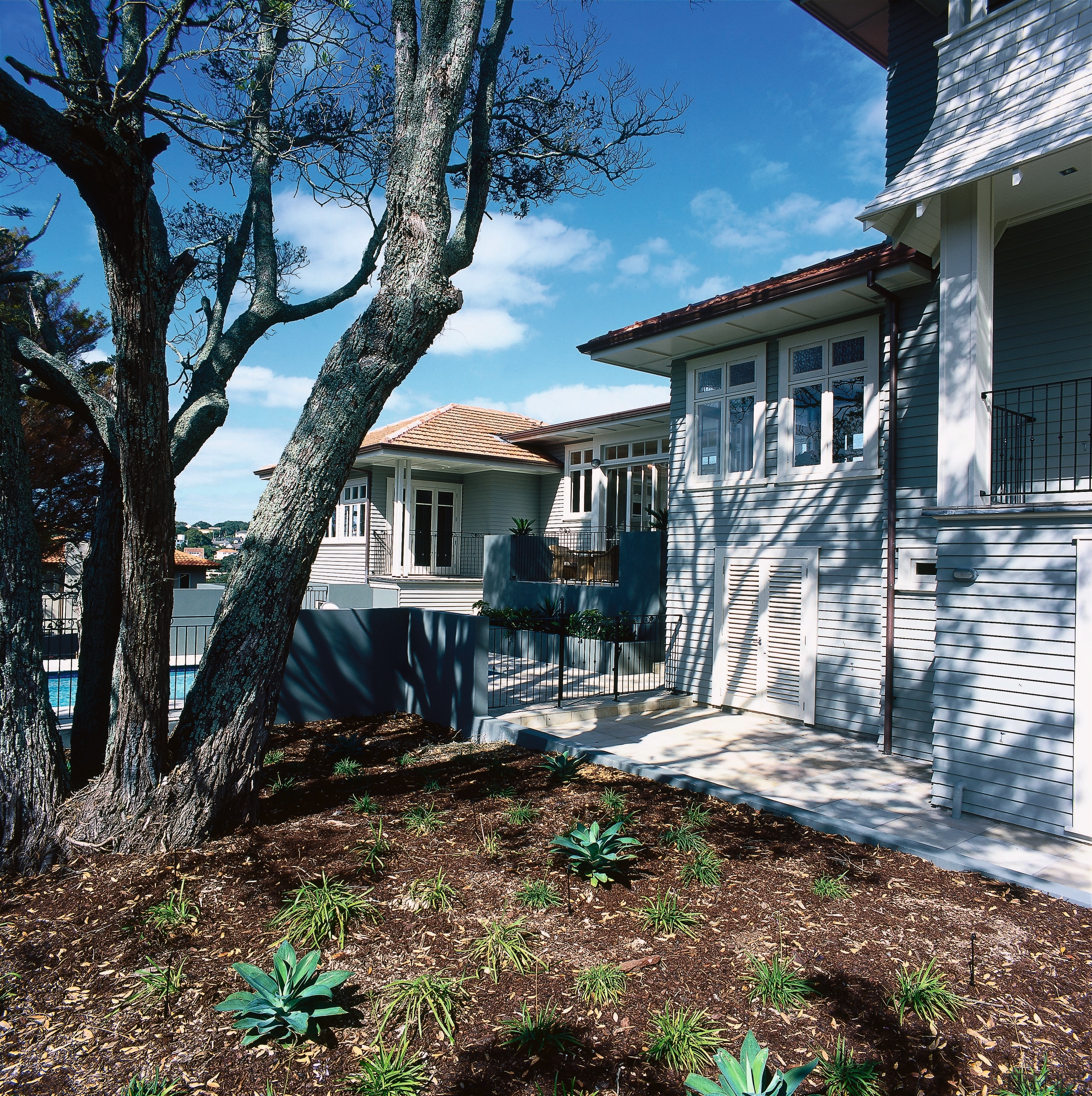 Exterior of weatherboard house with fenced pool area. architecture, backyard, building, cottage, estate, facade, home, house, landscape, landscaping, neighbourhood, outdoor structure, plant, property, real estate, residential area, siding, tree, wall, window, yard, black