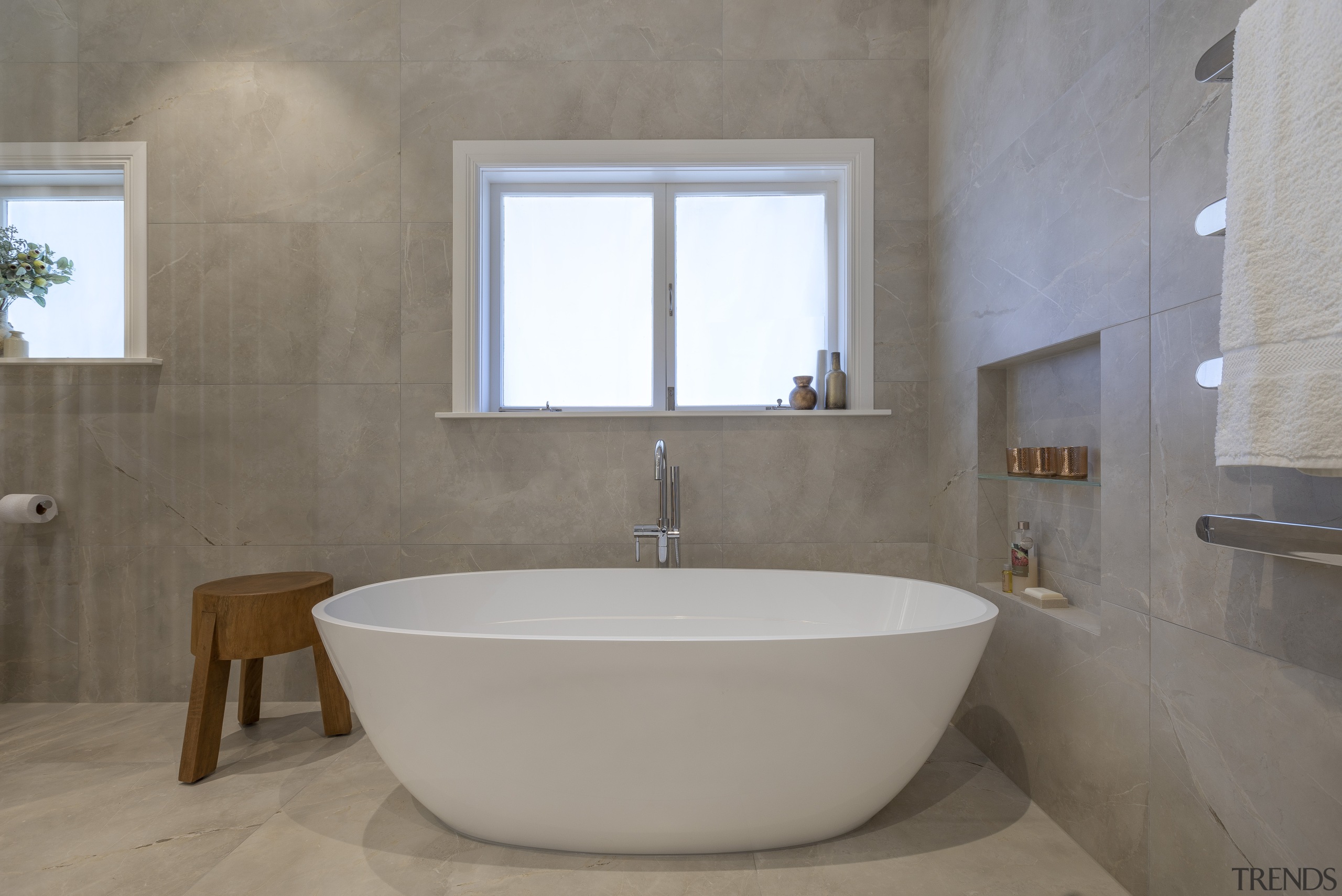 A recessed shelving niche supports bathing needs in architecture, bathroom, bathroom accessory, bathtub, building, ceramic, floor, flooring, home, house, interior design, limestone, marble, material property, plumbing fixture, property, room, tap, tile, wall, gray