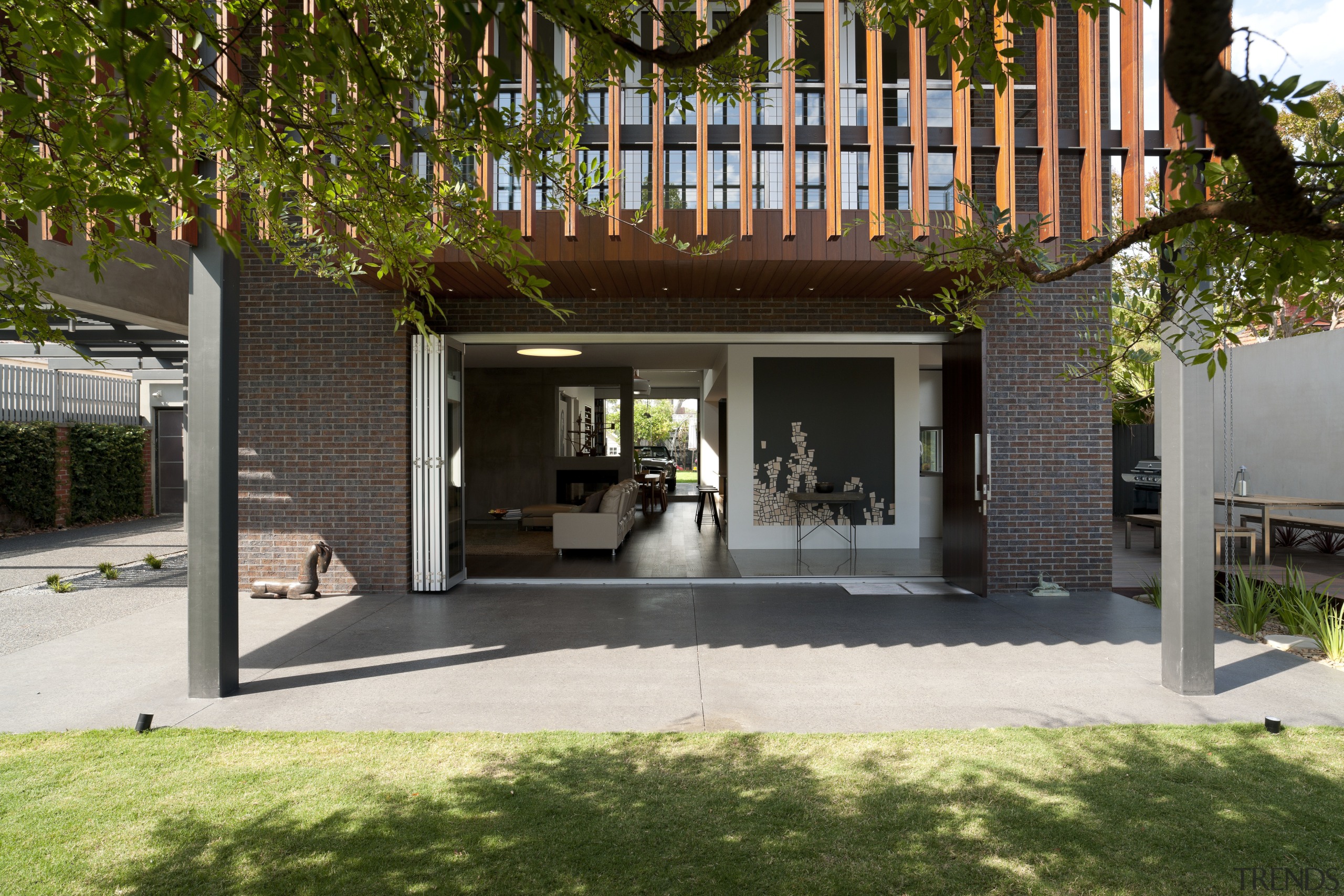 Large sliding doors open up the interior of architecture, backyard, courtyard, facade, home, house, outdoor structure, property, real estate, brown, black