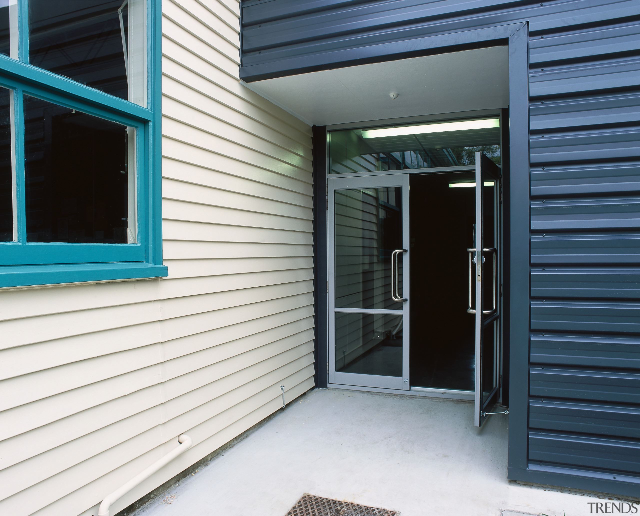 Exterior of school building with white weatherboards, and door, facade, home, house, property, real estate, siding, window, white, black