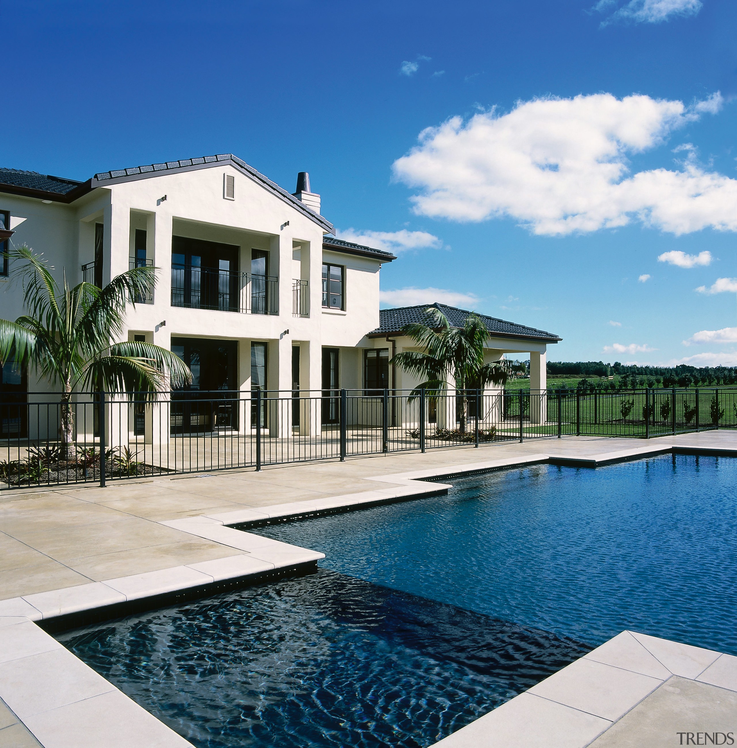 View of the outdoor living area of this condominium, elevation, estate, home, house, mansion, property, real estate, residential area, resort, sky, swimming pool, villa, water, white, blue