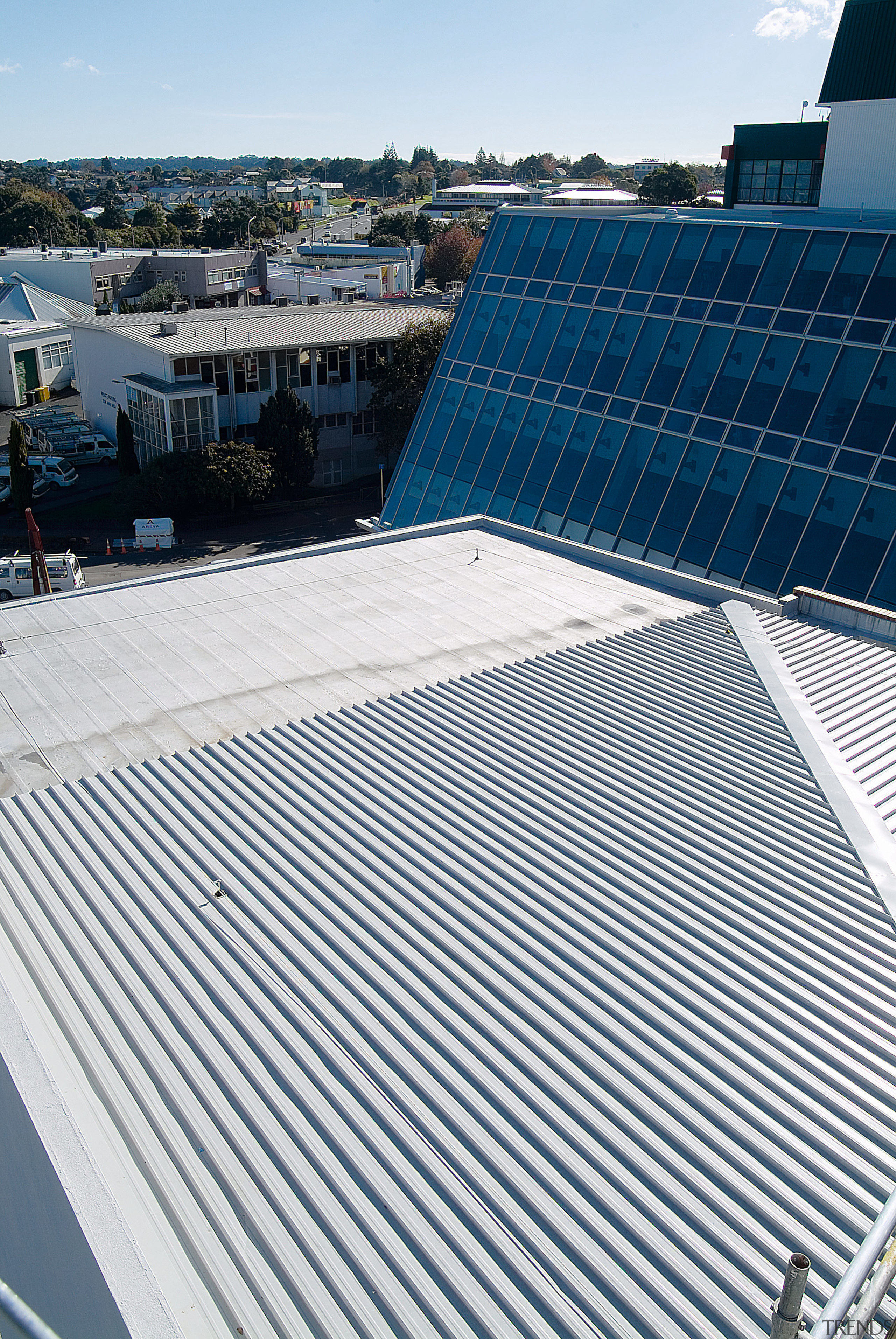 View of expansive grey roofing on building, and daylighting, daytime, energy, line, roof, sky, solar energy, solar panel, solar power, structure, white