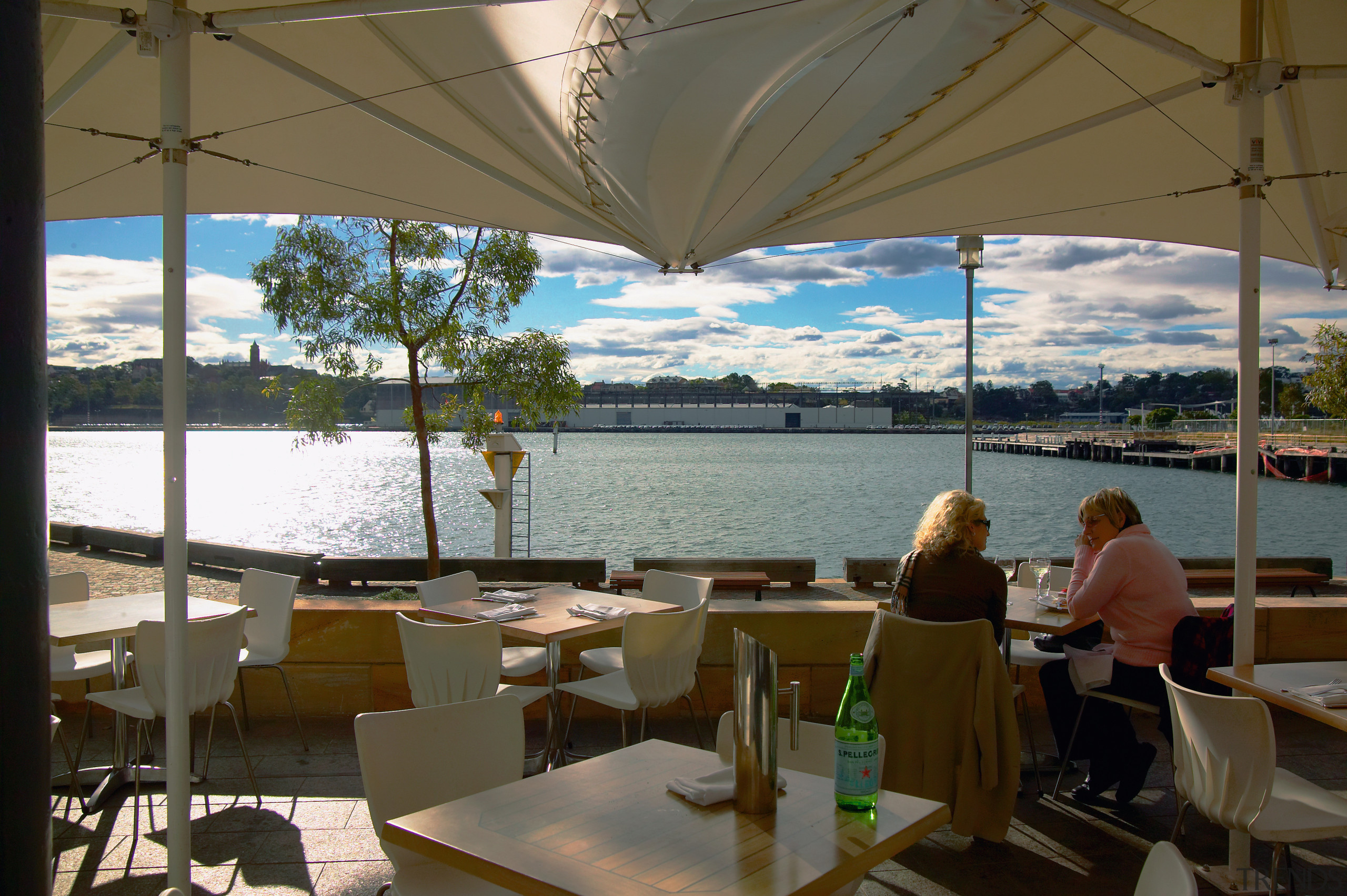 Waterfront seating area with tables and chairs, and resort, restaurant, vacation, water, brown, gray