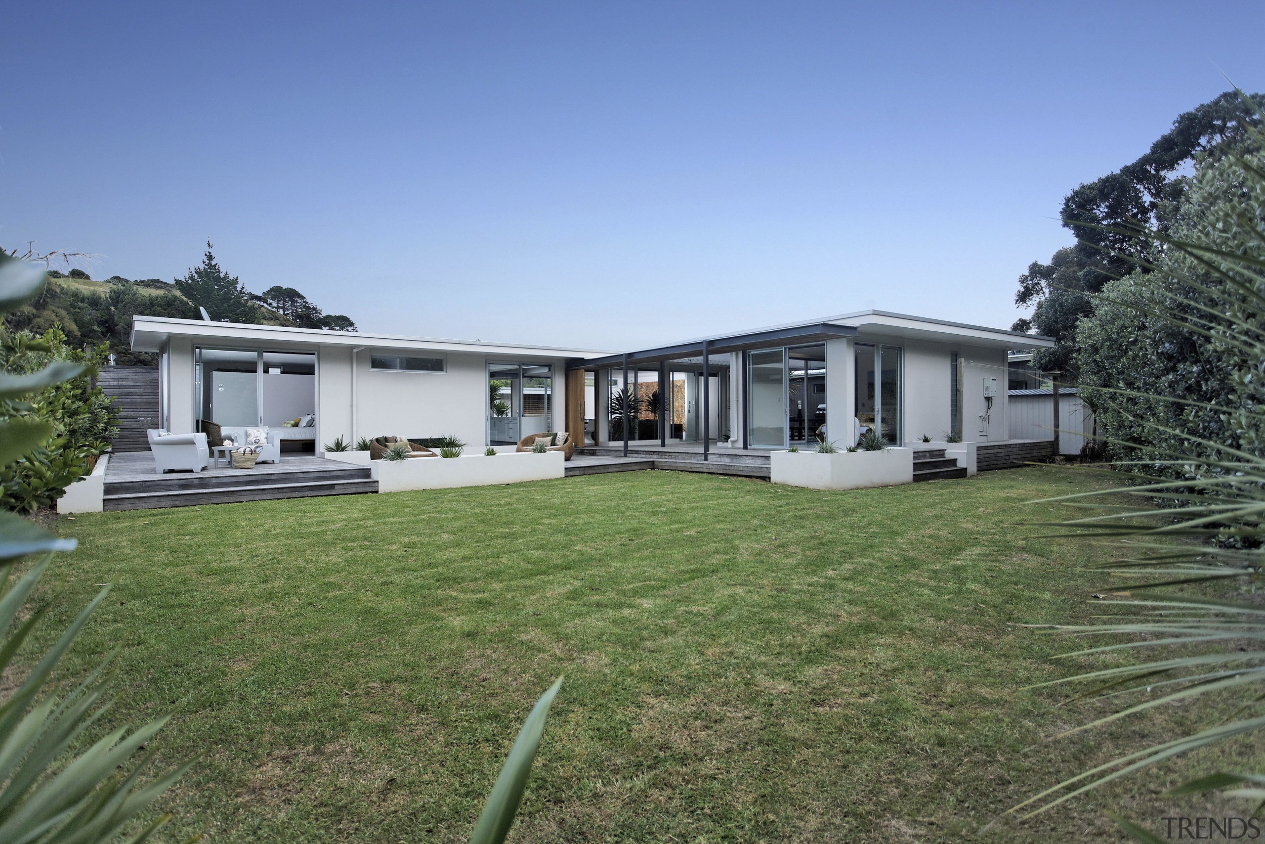 Overview of the exterior design of this modern backyard, cottage, estate, facade, home, house, land lot, landscape, property, real estate, residential area, villa, yard, teal, green