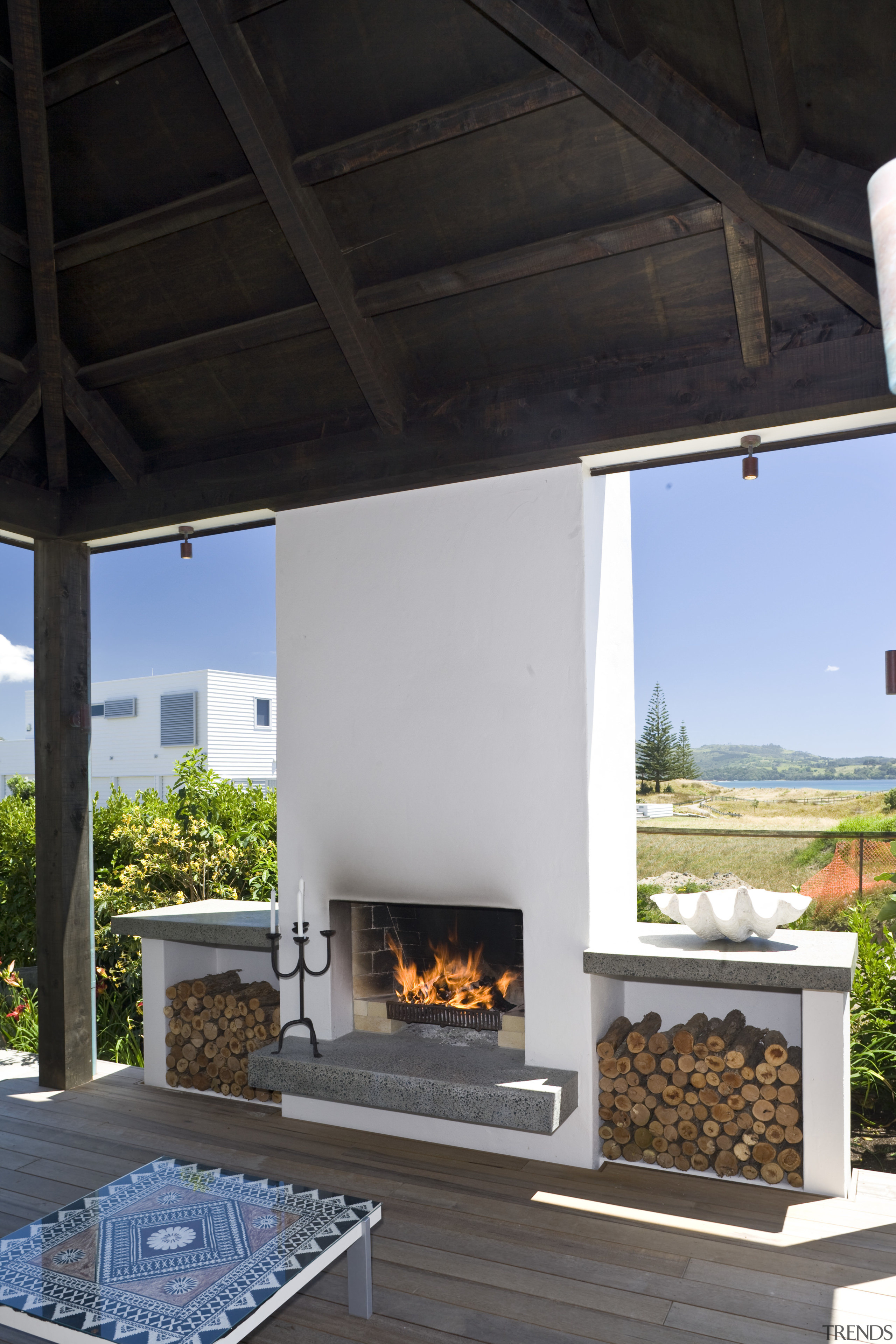 View of the deck with outdoor fireplace, decking, fireplace, hearth, black, gray