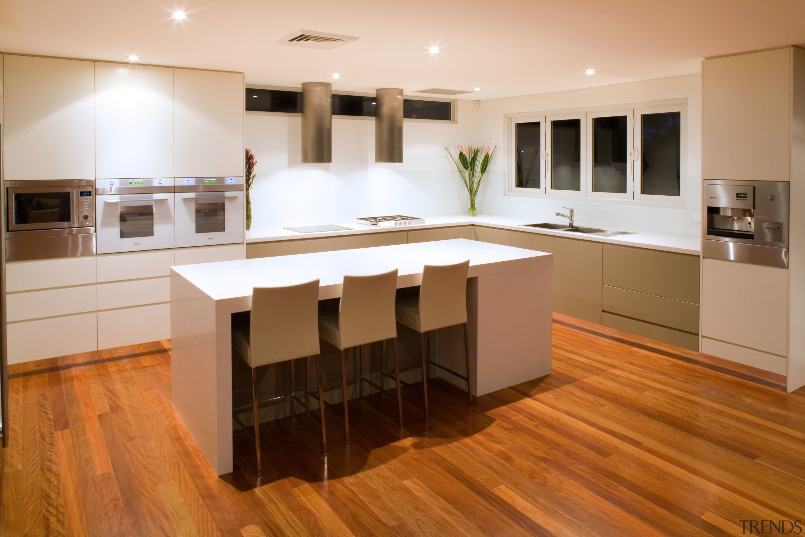 The island bench of this contemporary kitchen functions cabinetry, countertop, cuisine classique, floor, flooring, hardwood, interior design, kitchen, laminate flooring, room, wood, wood flooring, brown