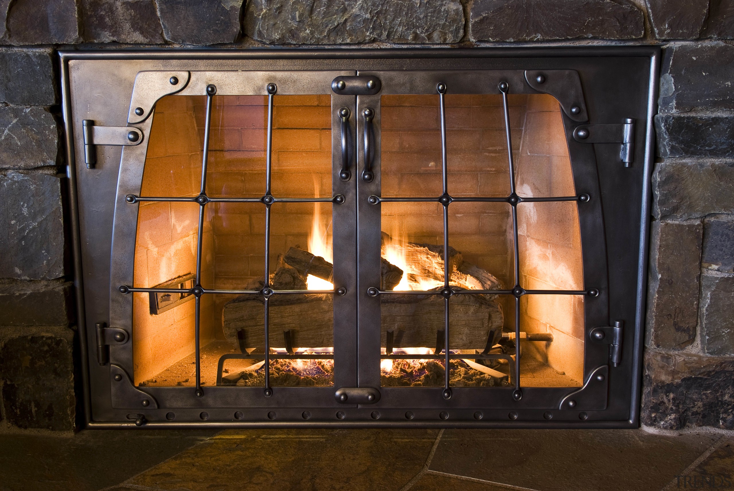 Image of fireplace in billiard room which has fire screen, fireplace, hearth, heat, masonry oven, wood burning stove, black, brown