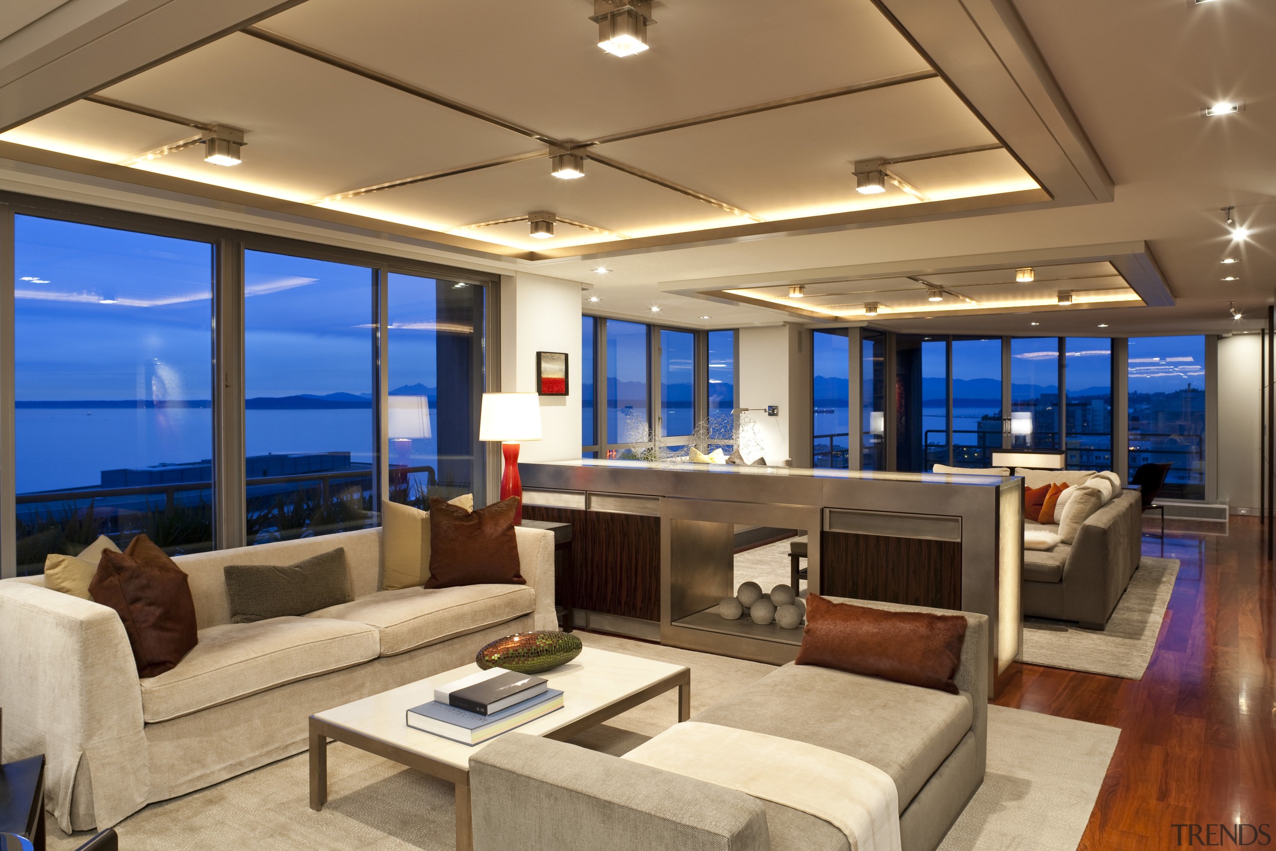 View of living space featuring rosewood flooring, customized ceiling, deck, interior design, living room, penthouse apartment, real estate, yacht, brown, orange