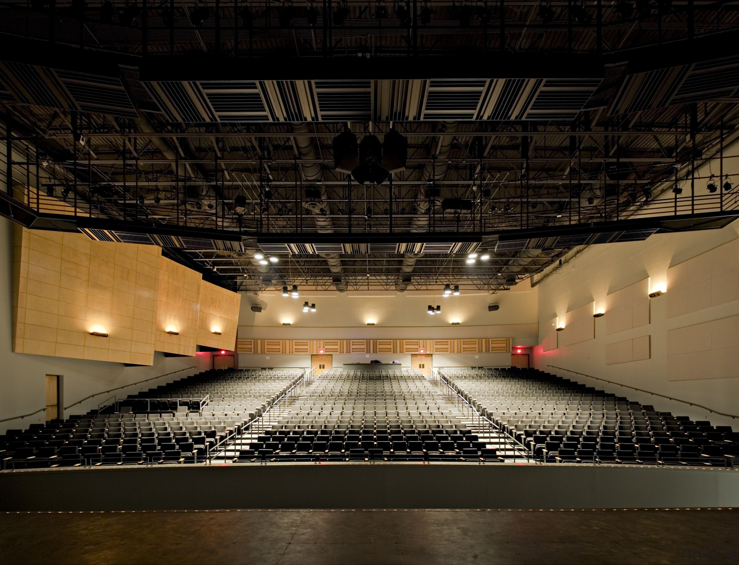View of the auditorium which has more subdued architecture, auditorium, darkness, light, lighting, night, performing arts center, structure, theatre, black, brown