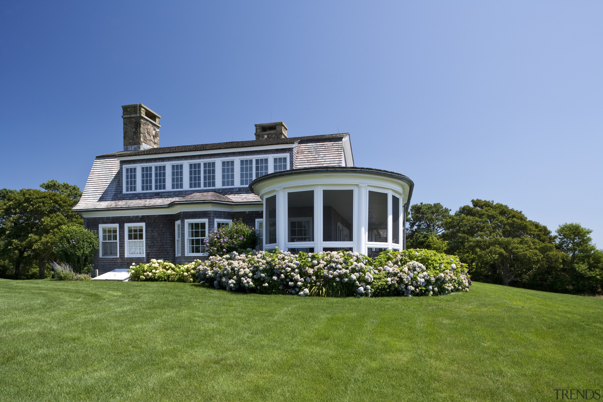 Exterior view of a New-England styled vacation home. cottage, estate, facade, farmhouse, grass, home, house, landscape, landscaping, lawn, mansion, plant, plantation, property, real estate, residential area, siding, sky, villa, window, teal