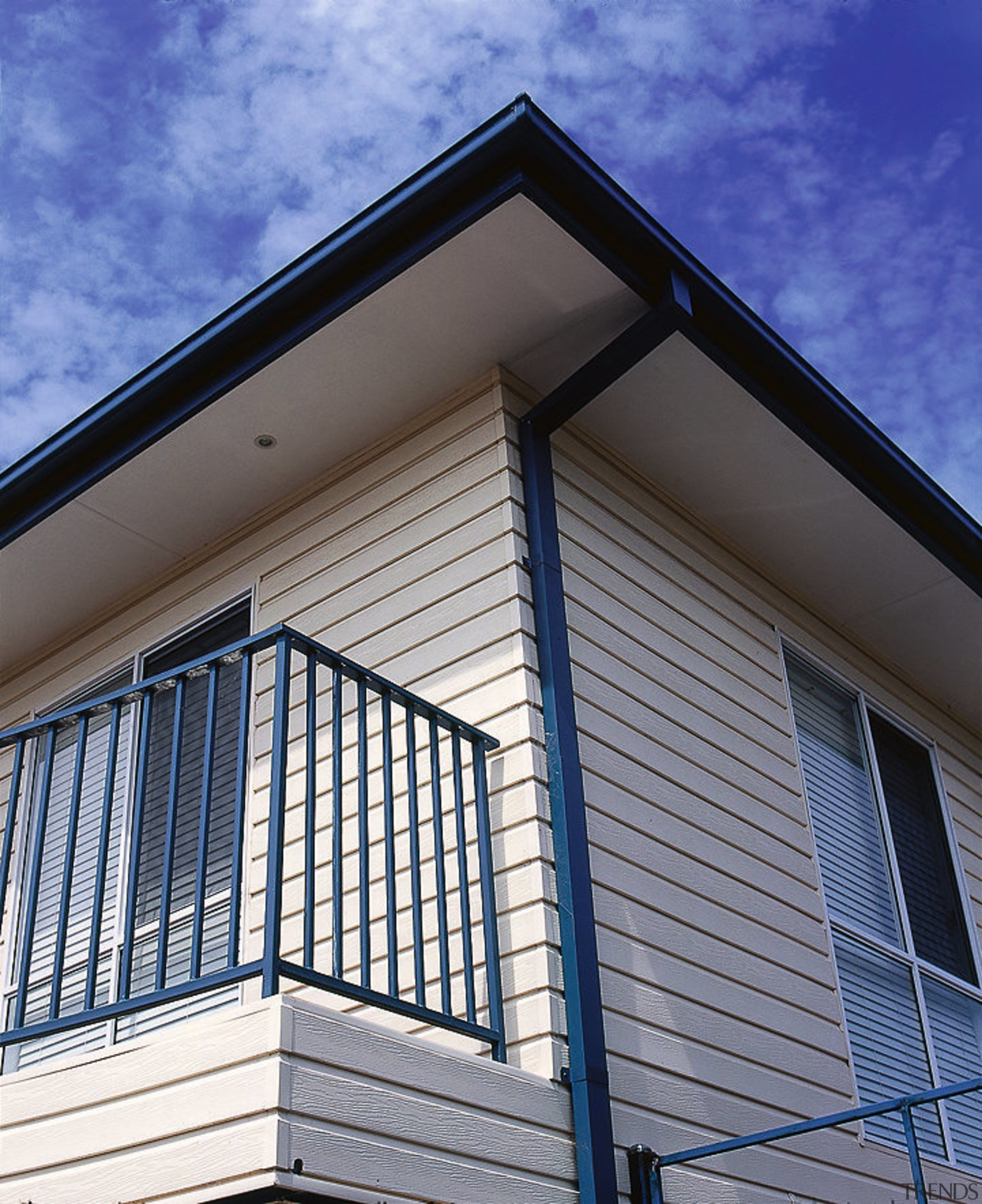 View of the side of this home - architecture, balcony, building, commercial building, daylighting, daytime, facade, home, house, line, real estate, residential area, roof, siding, sky, structure, window, blue, gray