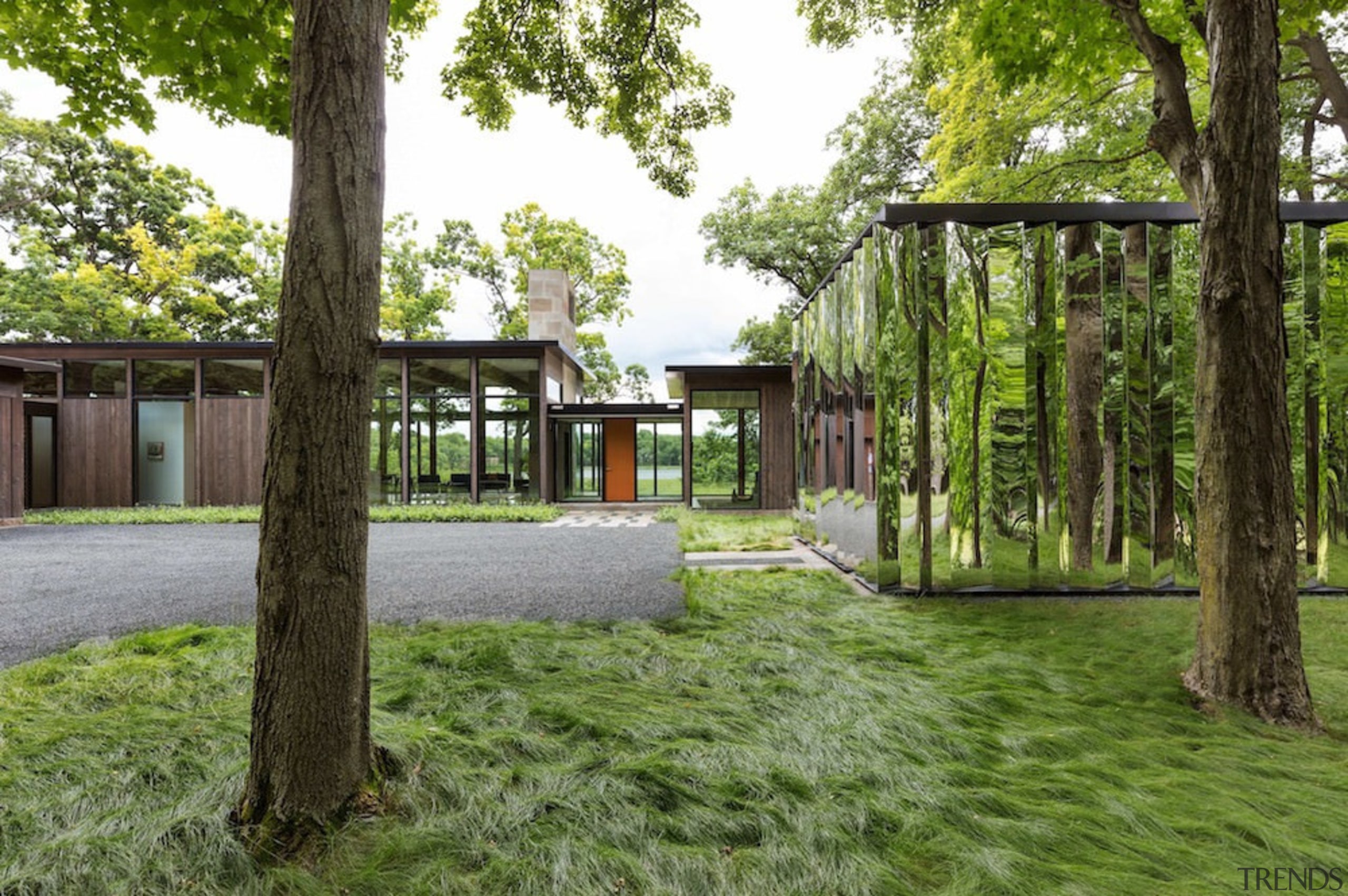 The home sits relatively low, respecting the surrounding architecture, backyard, cottage, estate, grass, home, house, landscape, park, pavilion, plant, real estate, tree, yard, green