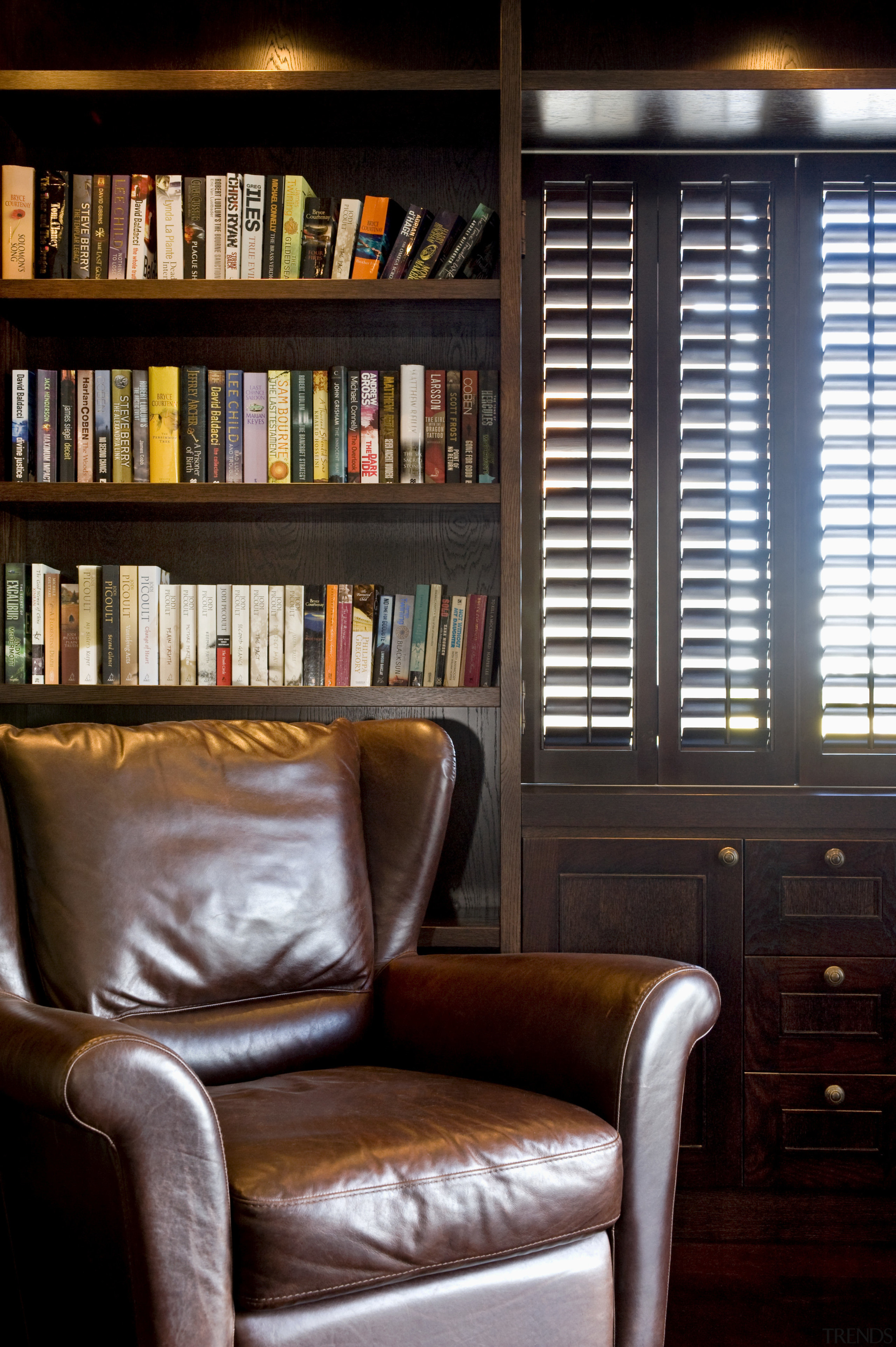 Image of dark stained library shelving and cabinetry bookcase, chair, furniture, home, interior design, library, living room, shelf, shelving, window, wood, black