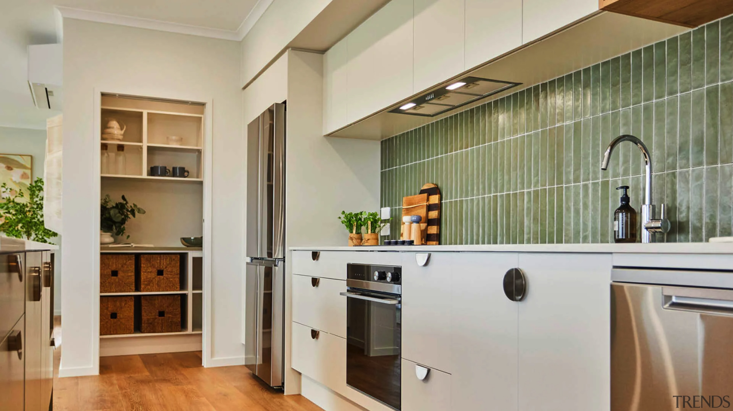 An integrated overhead extractor, sea-grass toned splashback tiles 