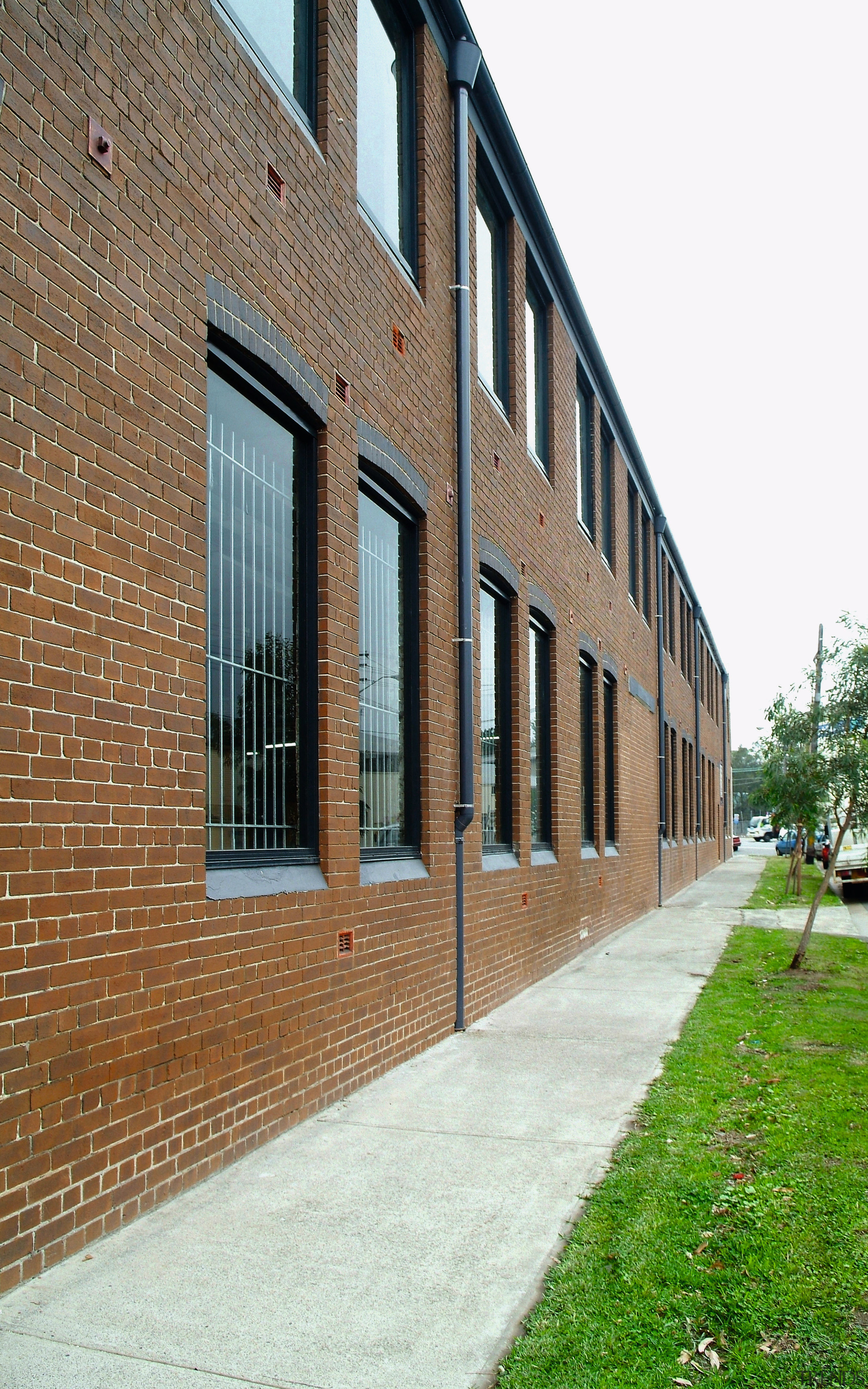 A view of this 1970s masonry warehouse with apartment, architecture, brick, brickwork, building, estate, facade, house, neighbourhood, property, real estate, residential area, wall, window, white, brown