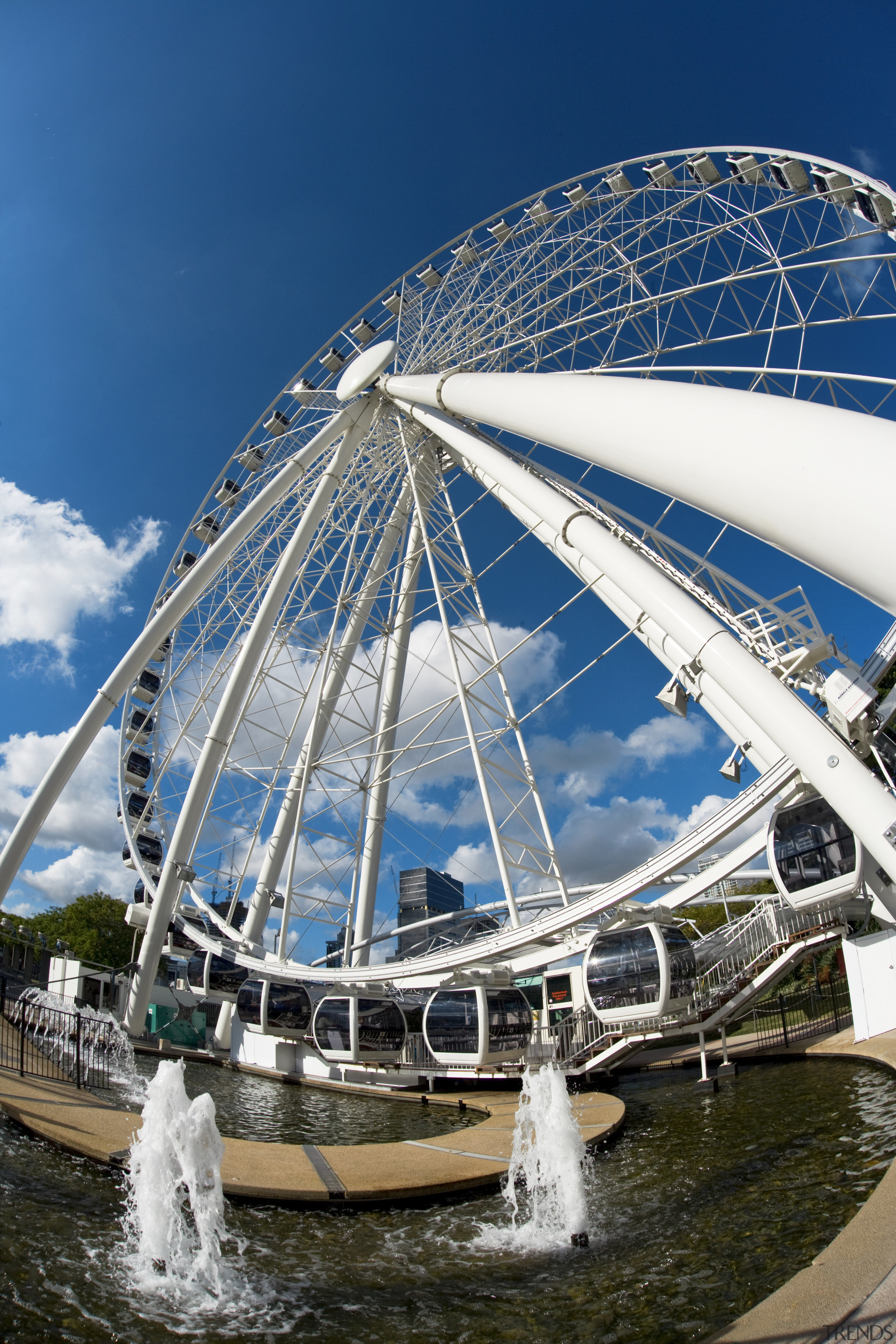 Image of a development which is part of amusement park, architecture, ferris wheel, fixed link, landmark, recreation, reflection, sky, tourist attraction, water, blue