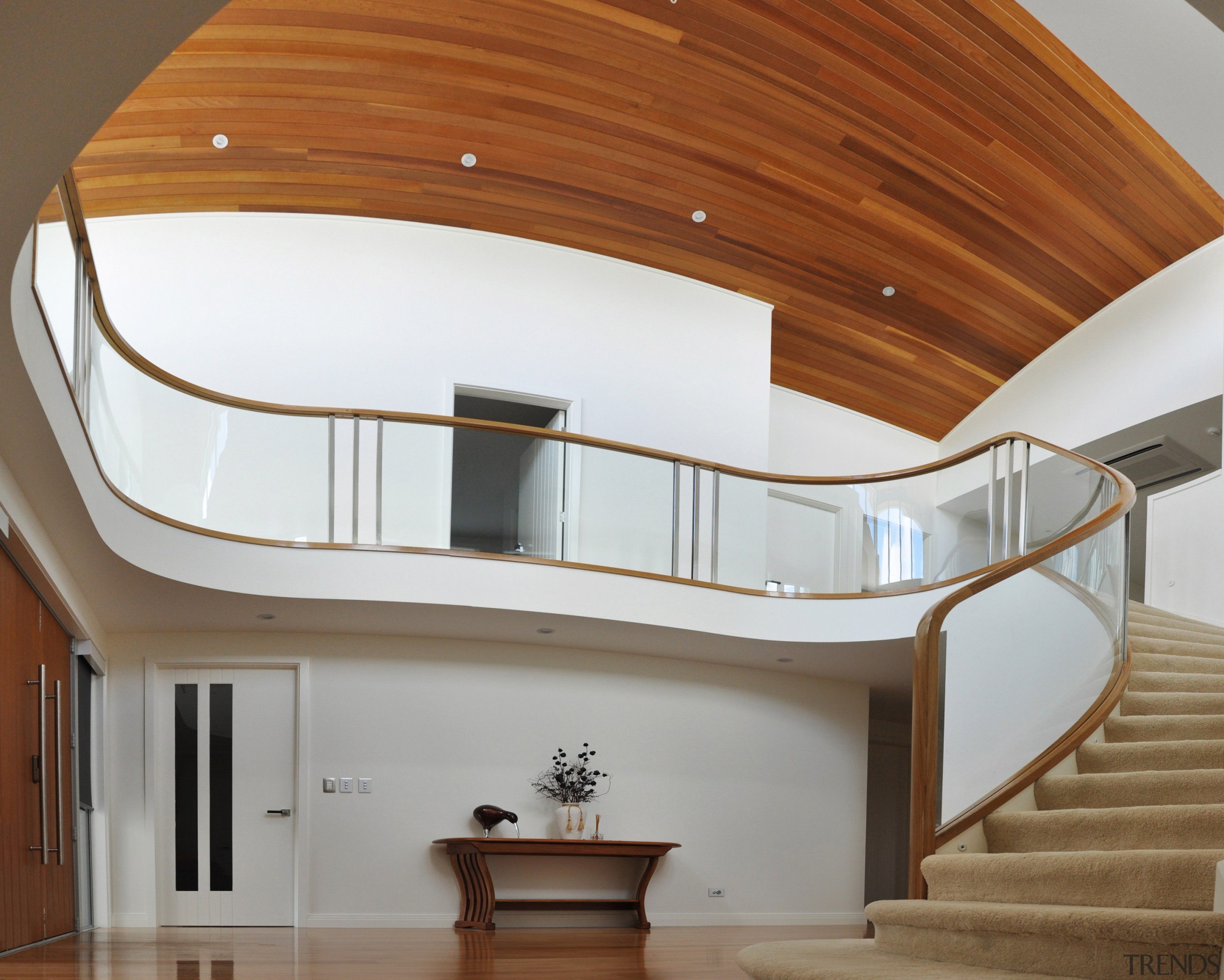 A curvaceous glass balustrade framed in wood by architecture, ceiling, daylighting, furniture, handrail, home, house, interior design, product design, property, stairs, brown, gray